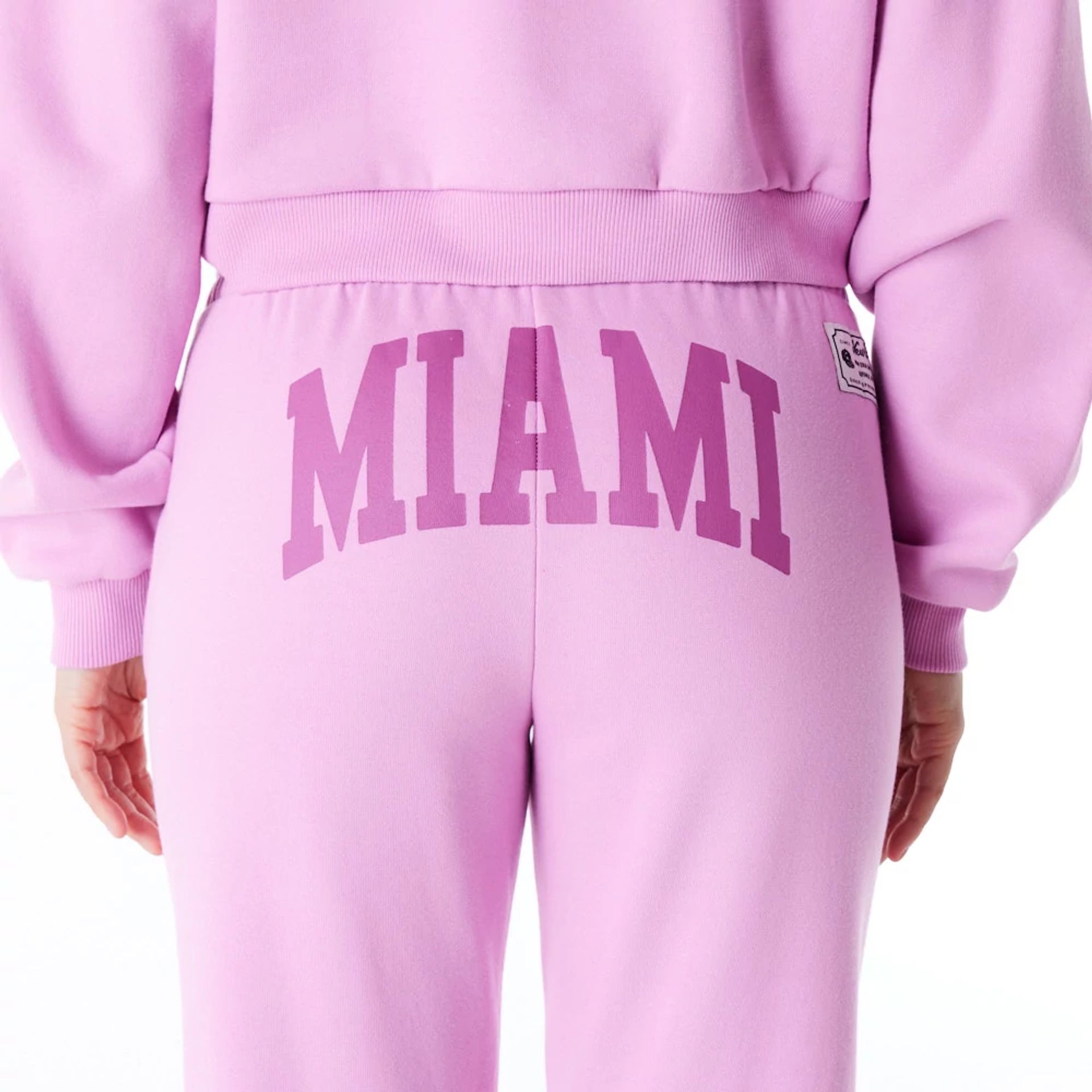 The Female model is wearing New Era Infill Pastel Pink Fleece Joggers 5