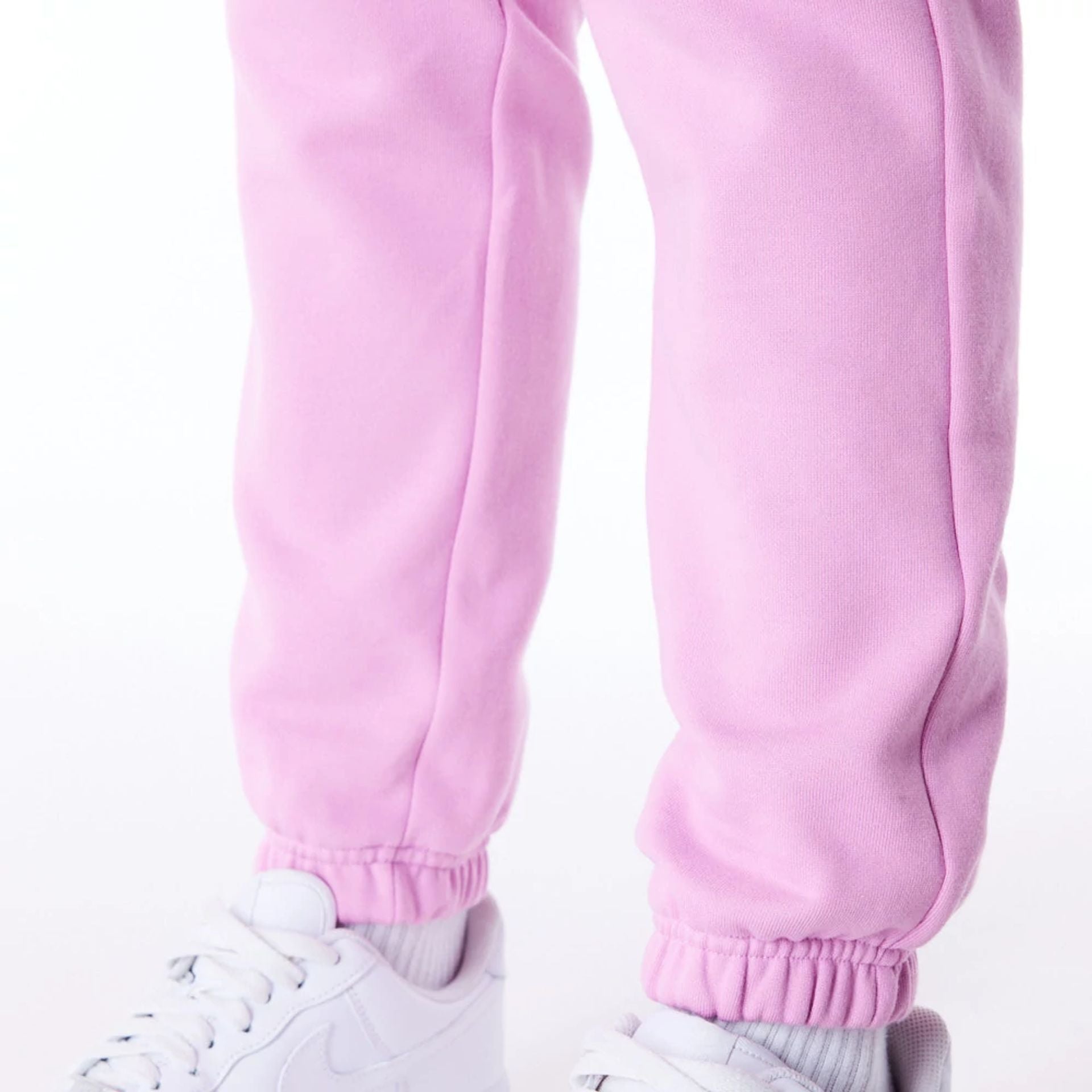 The Female model is wearing New Era Infill Pastel Pink Fleece Joggers 7