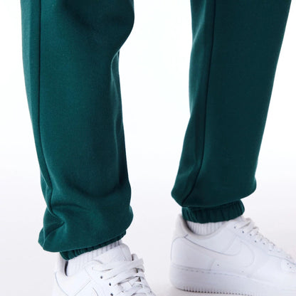 The Female model is wearing New Era Infill Dark Green Fleece Joggers 7