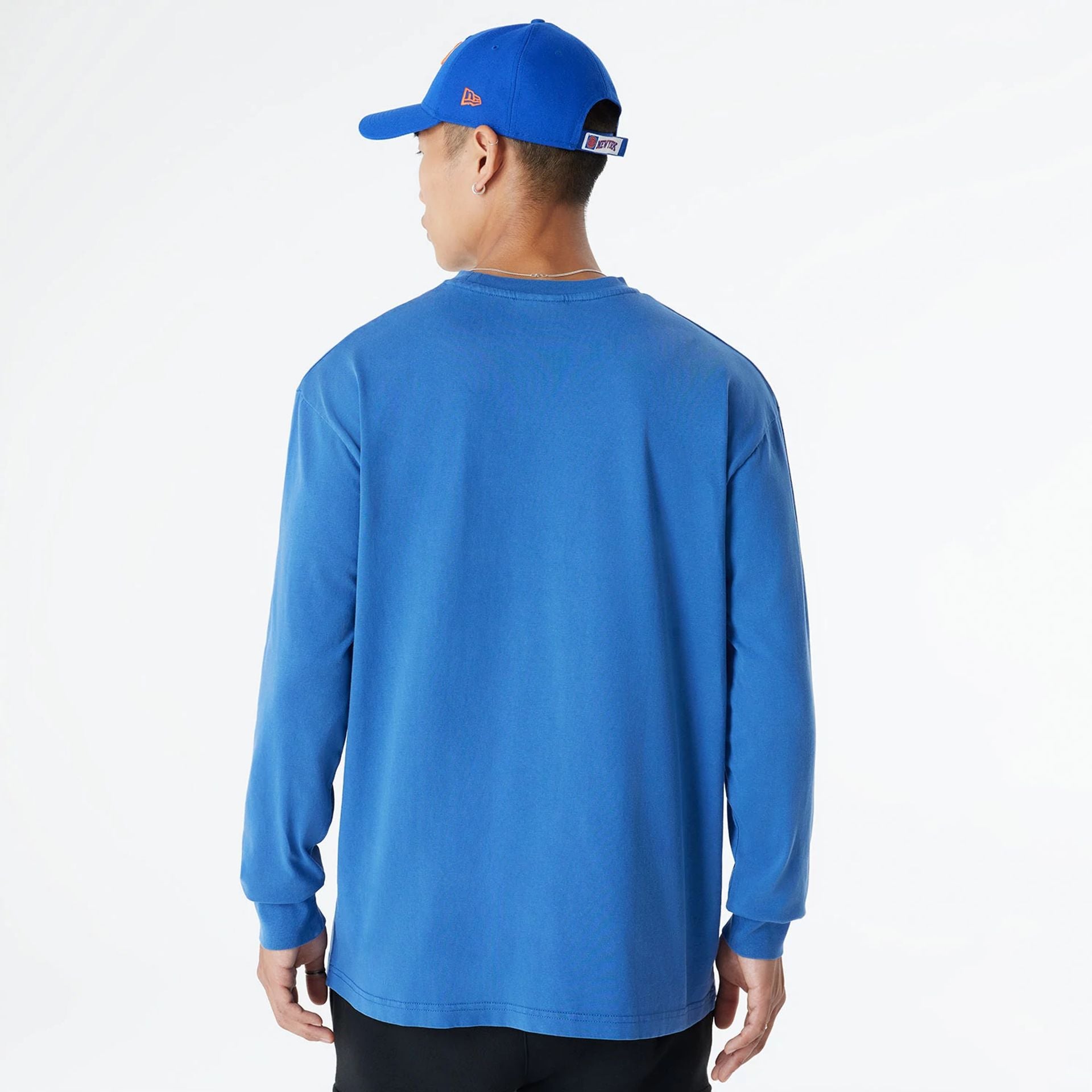 The Male model is wearing New York Knicks Oversized Essential Blue Oversized Long Sleeve T-Shirt 2