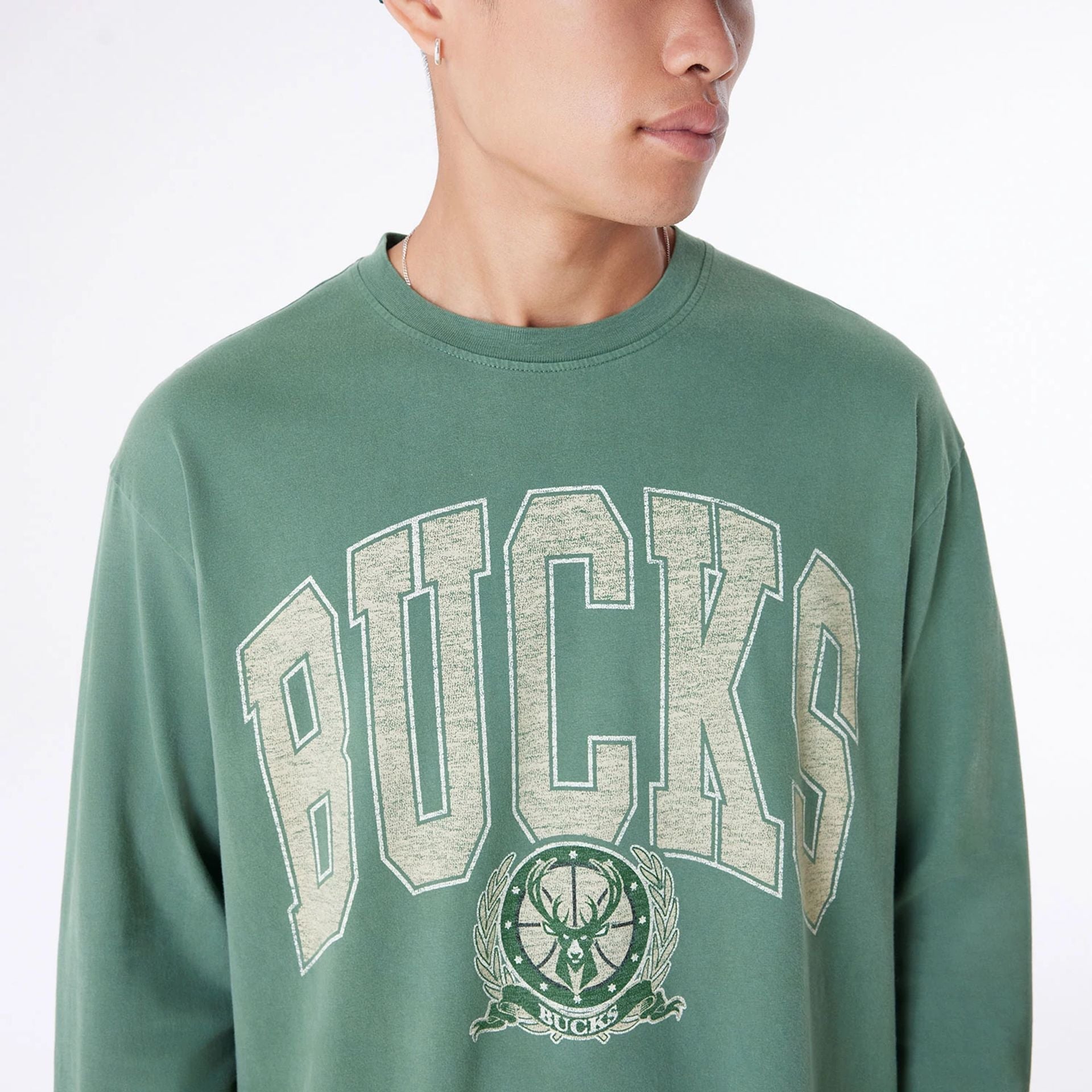 The Male model is wearing Milwaukee Bucks Oversized Essential Dark Green Oversized Long Sleeve T-Shirt 3