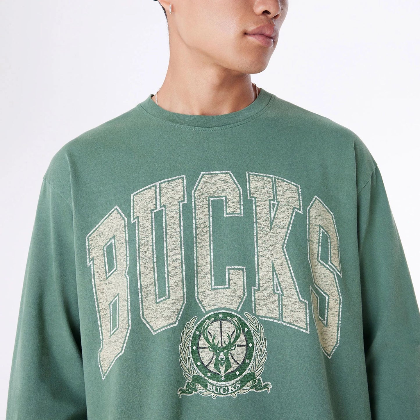 The Male model is wearing Milwaukee Bucks Oversized Essential Dark Green Oversized Long Sleeve T-Shirt 6