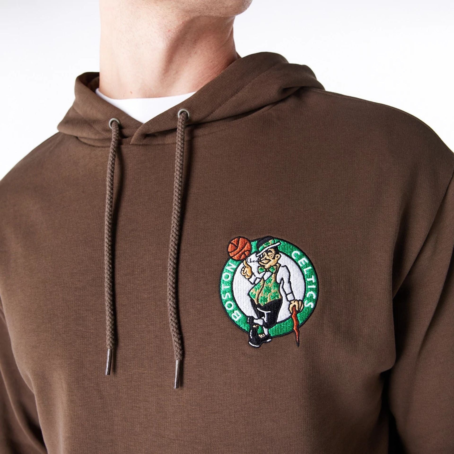 The Male model is wearing Boston Celtics League Essential Dark Brown Oversized Pullover Hoodie  1