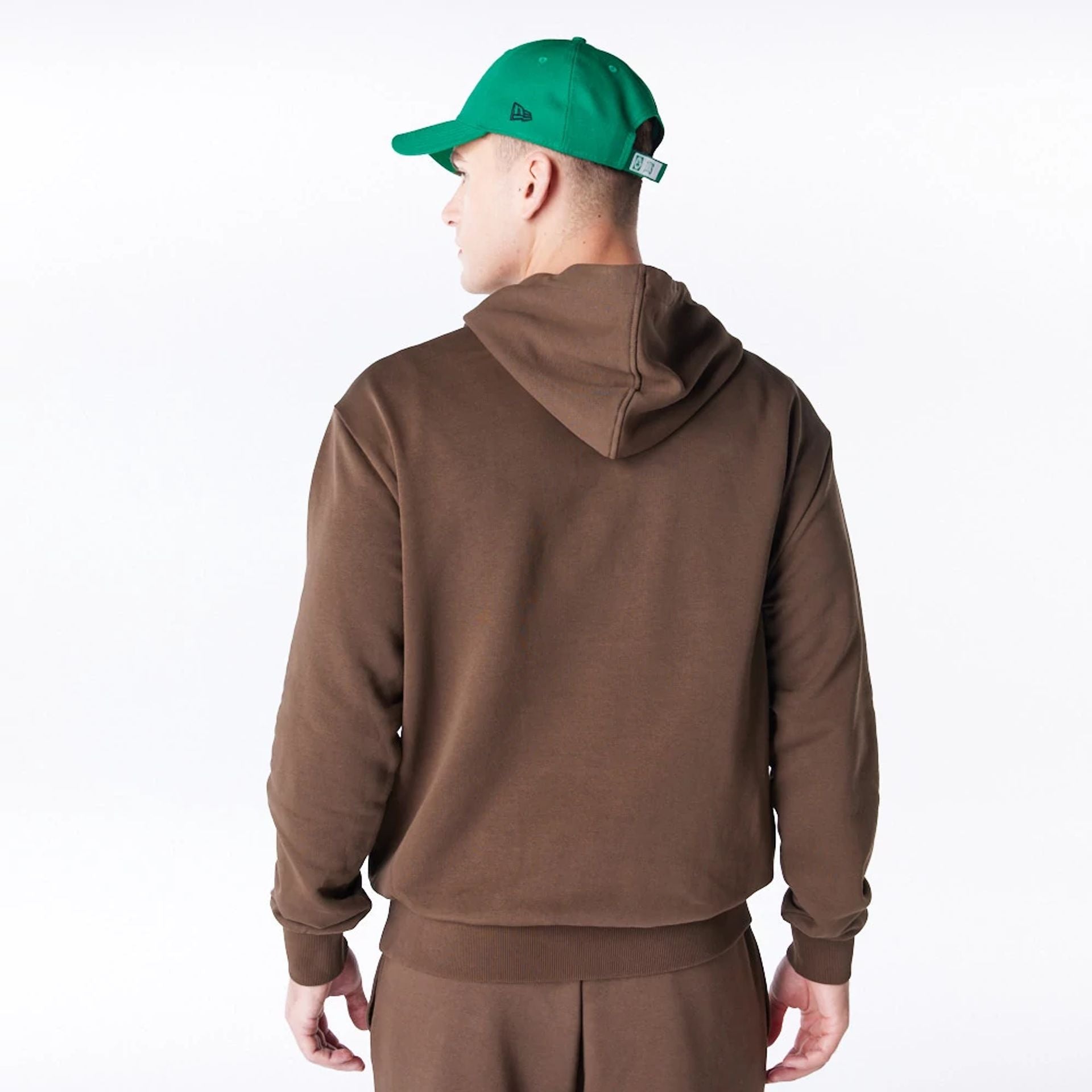 The Male model is wearing Boston Celtics League Essential Dark Brown Oversized Pullover Hoodie  7