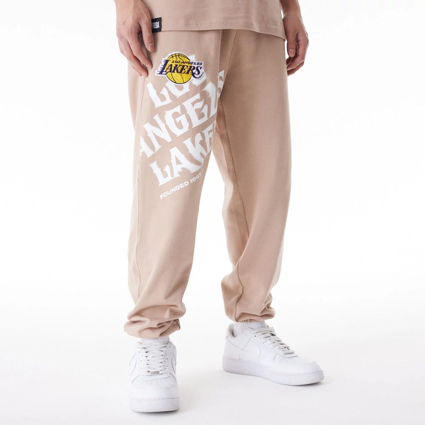 The Male model is wearing LA Lakers NBA Graphic Beige Joggers  1