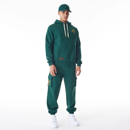 The Male model is wearing  New Era Script Logo Dark Green Oversized Pullover Hoodie  4