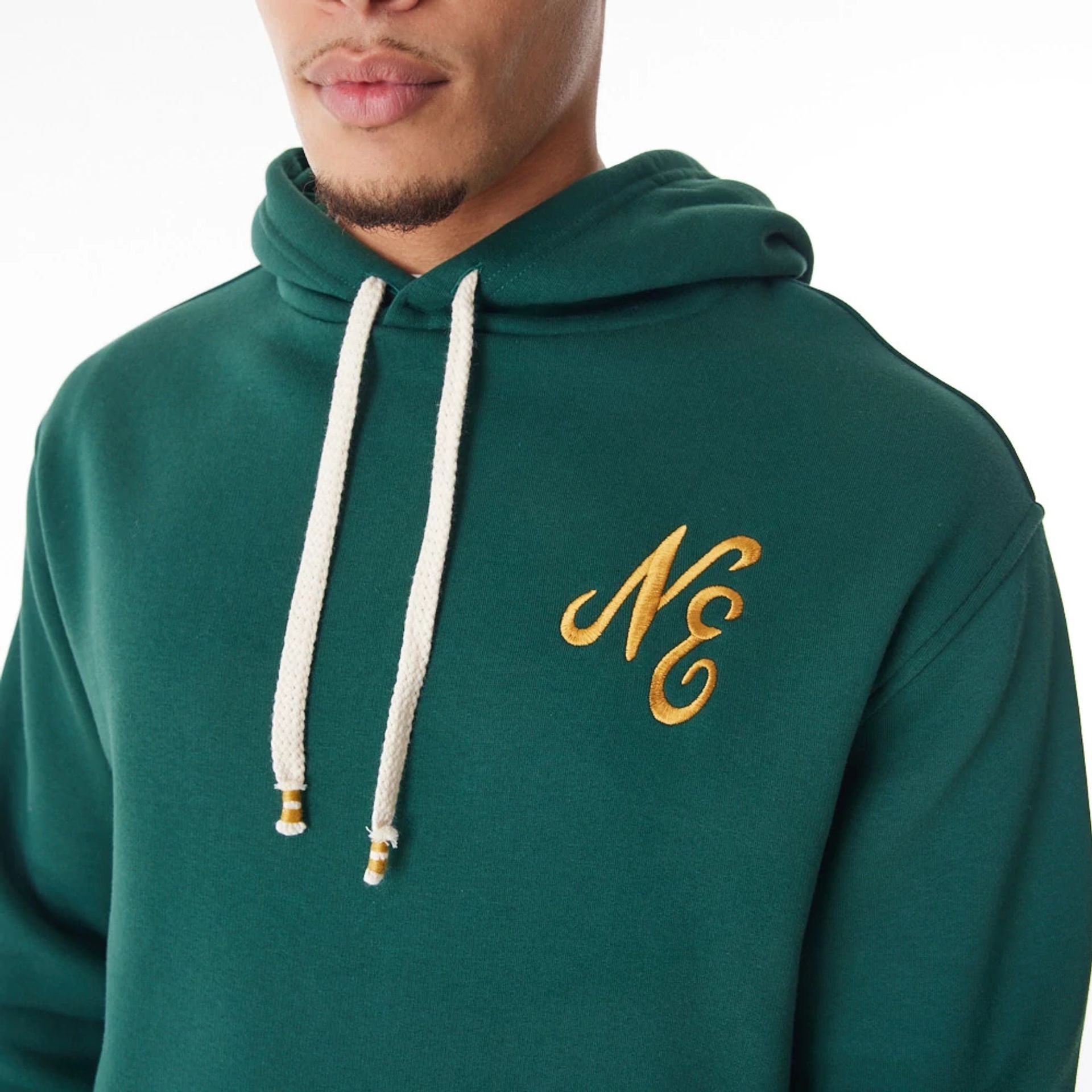 The Male model is wearing  New Era Script Logo Dark Green Oversized Pullover Hoodie  10