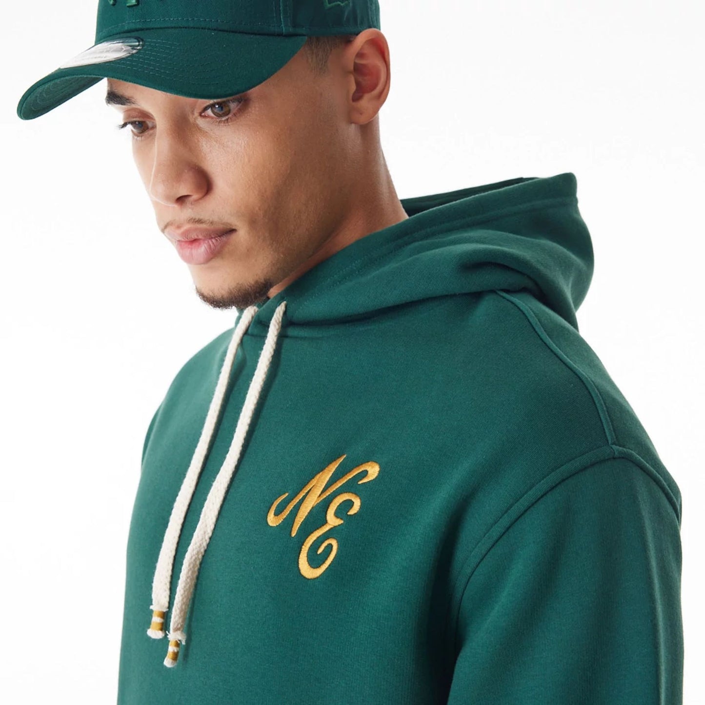 The Male model is wearing  New Era Script Logo Dark Green Oversized Pullover Hoodie  11