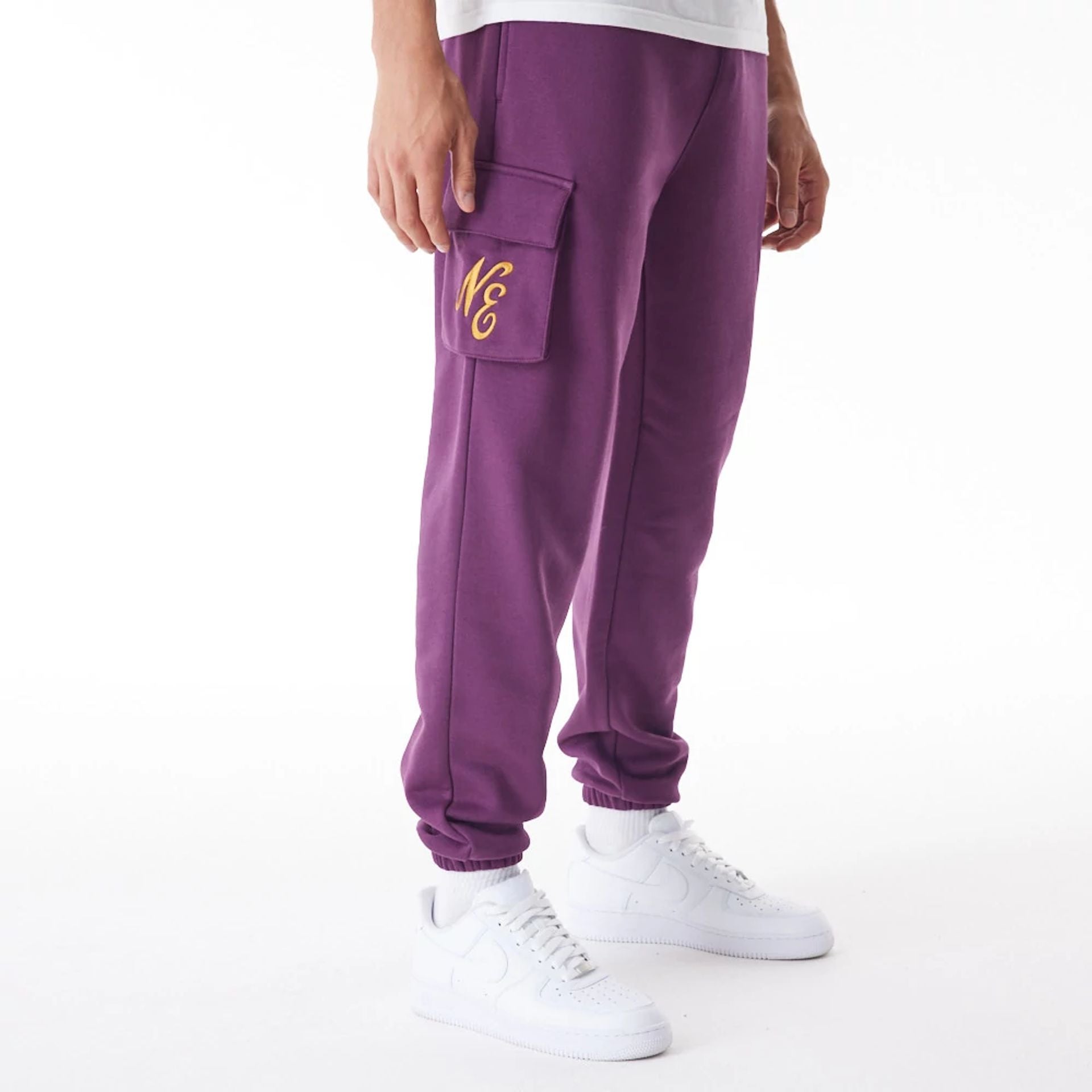 The Male model is wearing  New Era Script Cargo Dark Purple Joggers  1