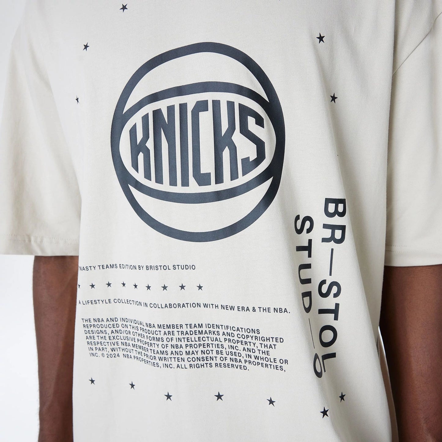 The Male model is wearing New York Knicks Bristol Studio x NBA Light Beige Oversized T-Shirt 5