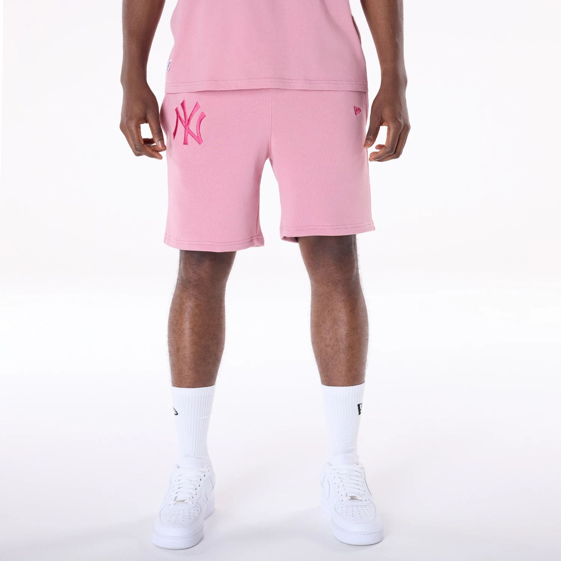 The Male model is wearing New York Yankees MLB League Essential Dark Pink Shorts 1