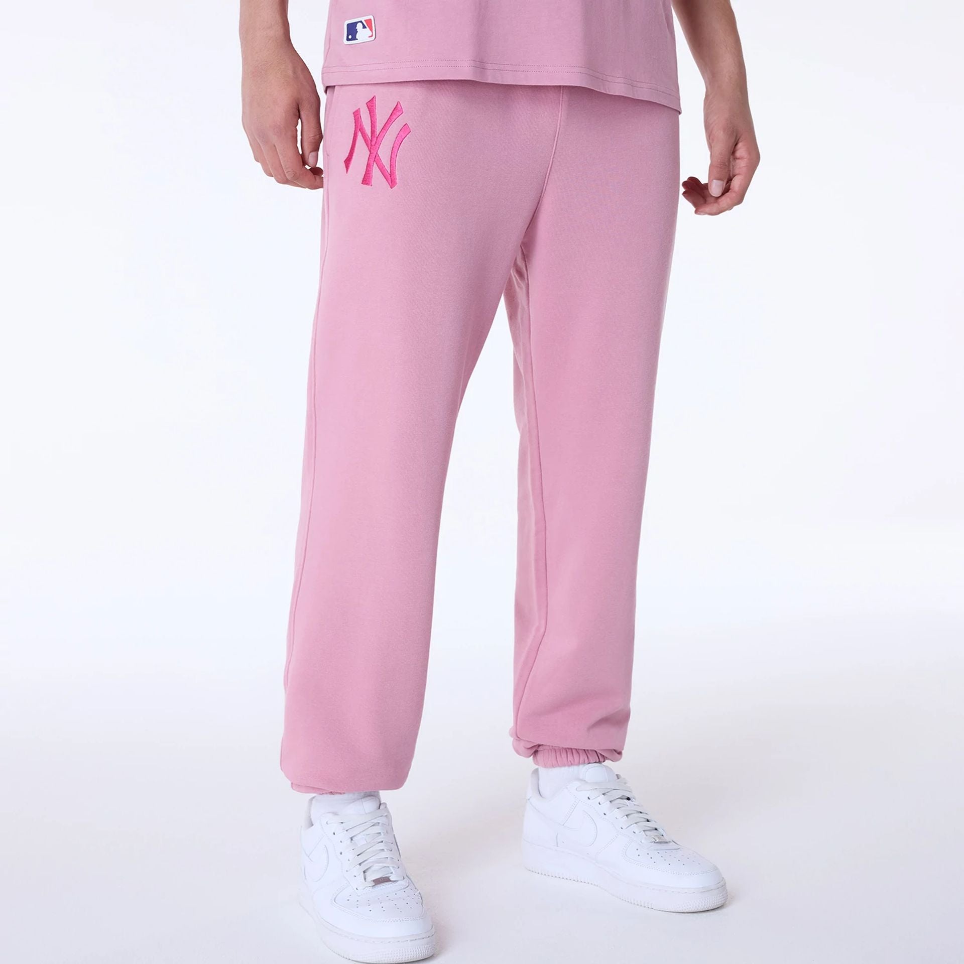 The Male model is wearing New York Yankees MLB League Essential Dark Pink Fleece Joggers 1