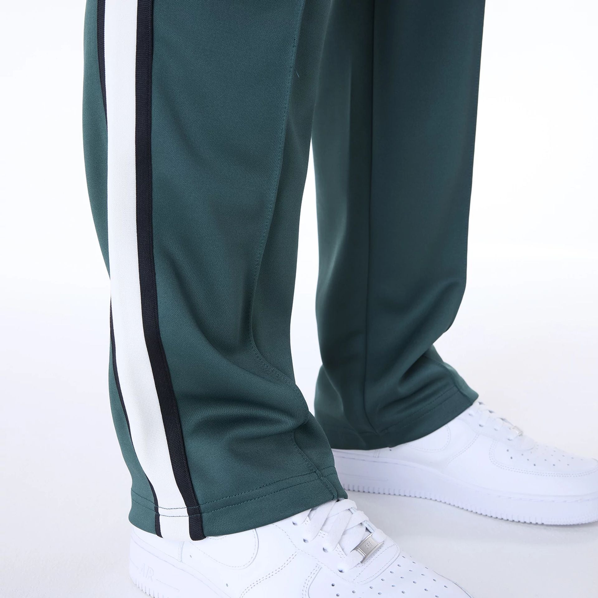 The Male model is wearing New Era Essential Dark Green Track Pants 3