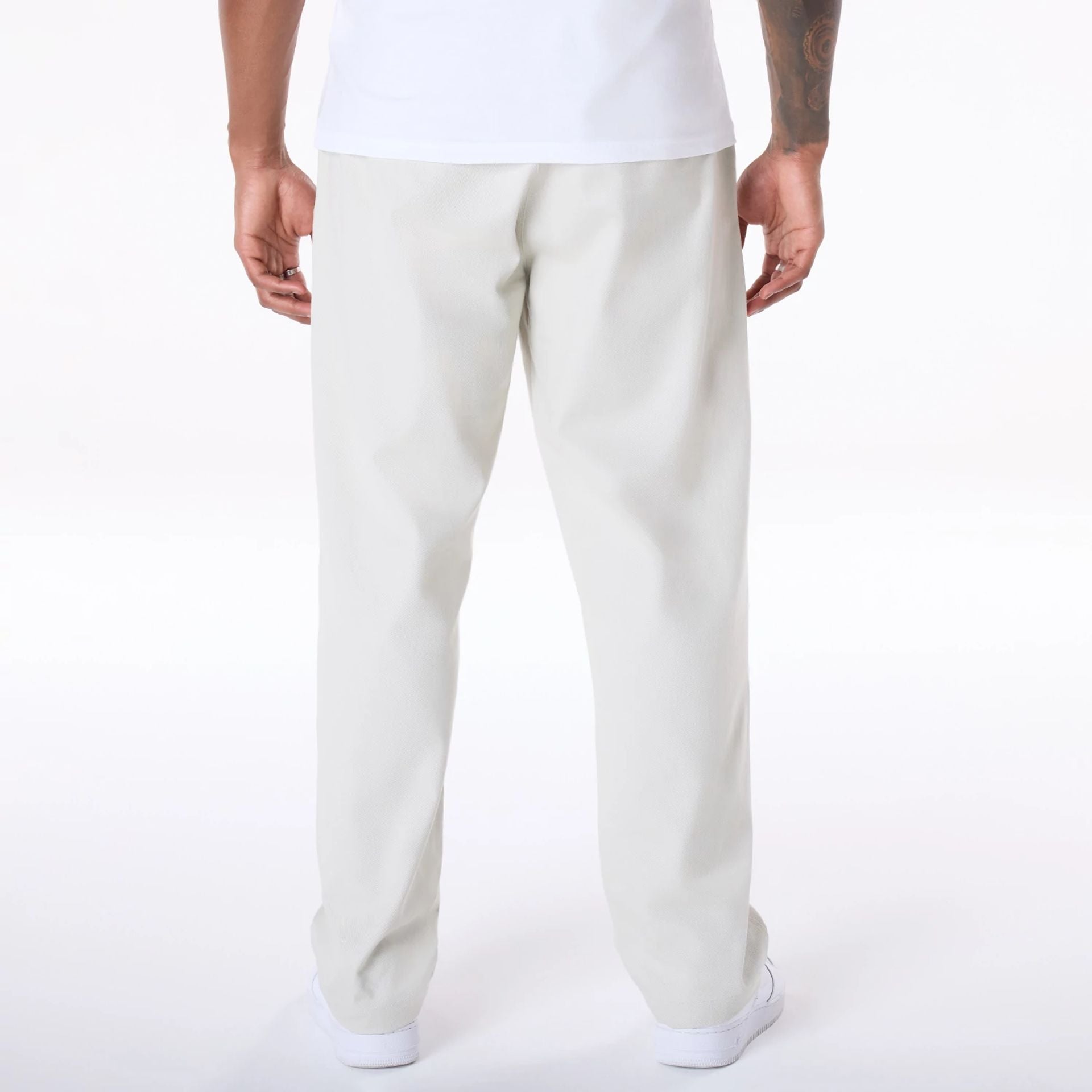 The Male model is wearing New Era Cream Chino Trousers 2