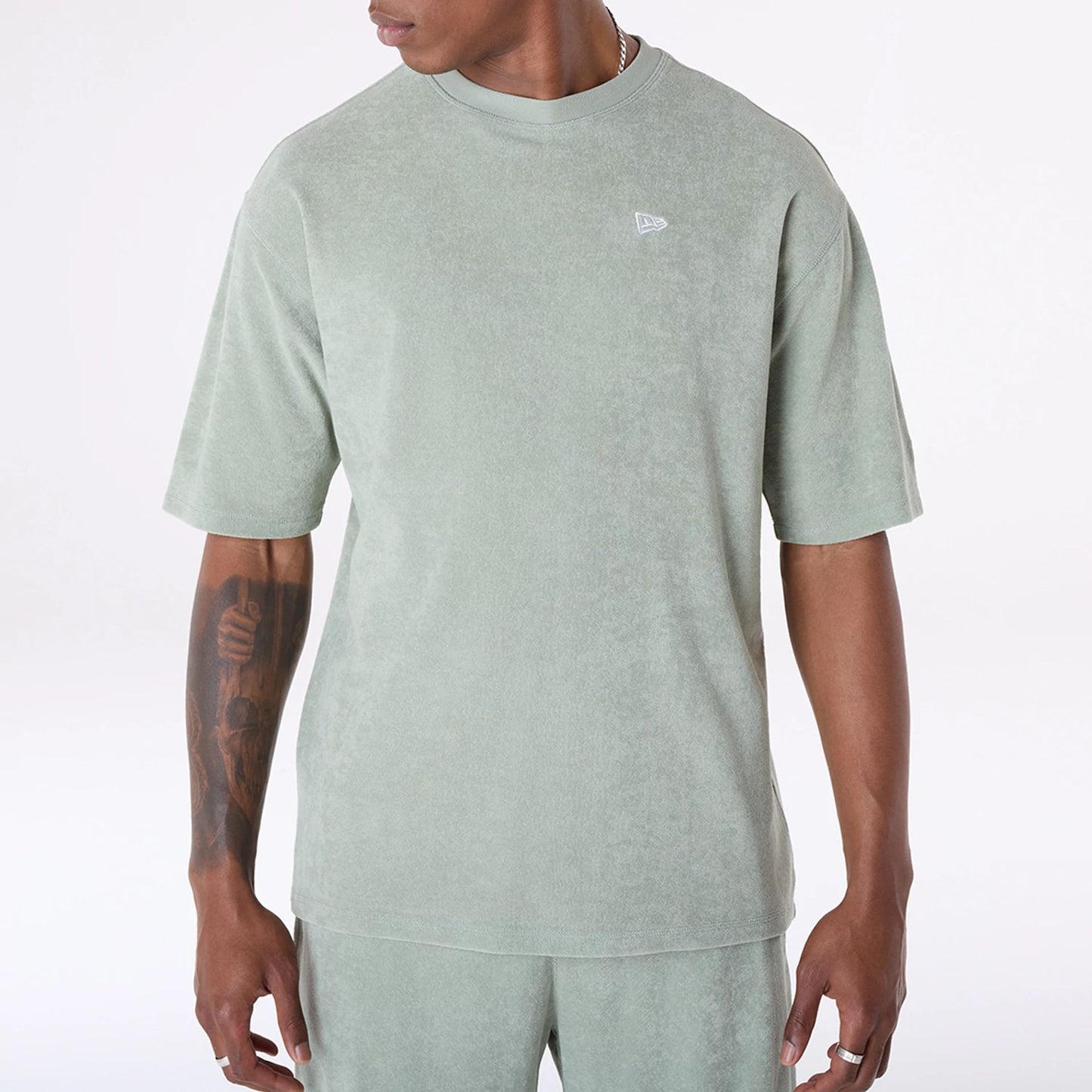 The Male model is wearing New Era Towelling Pastel Green Oversized T-Shirt 8