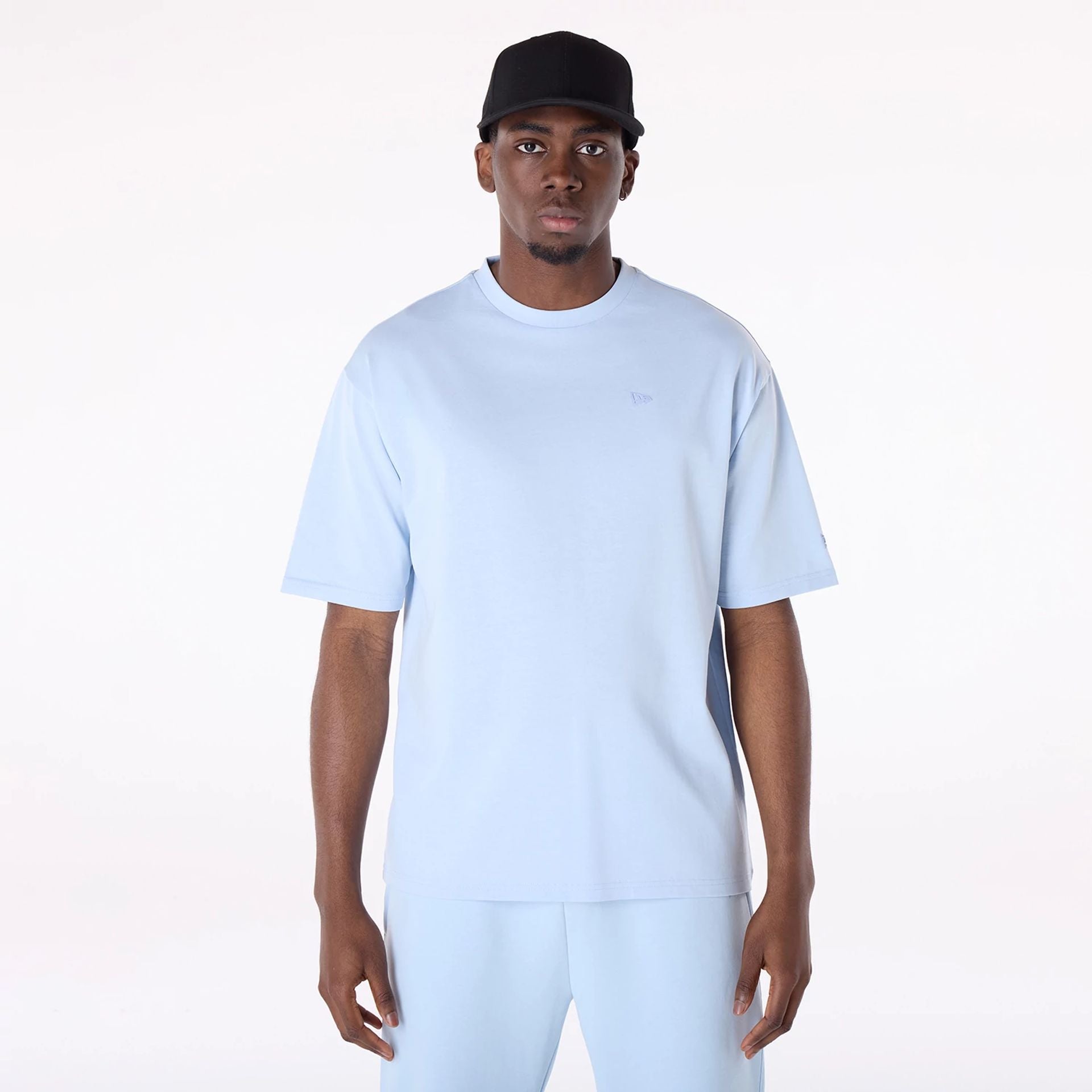 The Male model is wearing New Era Sticker Pastel Blue Oversized T-Shirt 1