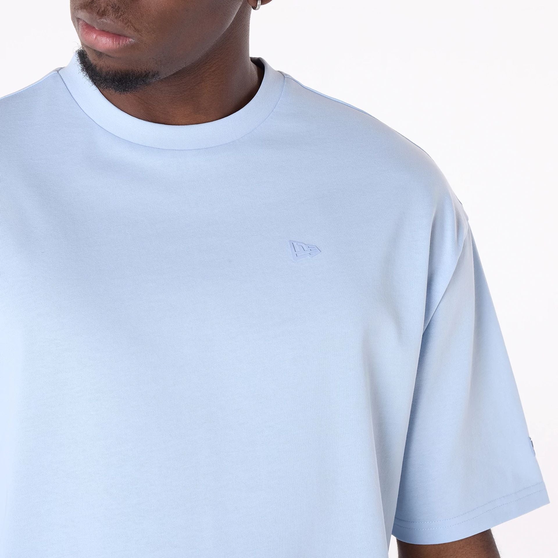 The Male model is wearing New Era Sticker Pastel Blue Oversized T-Shirt 7