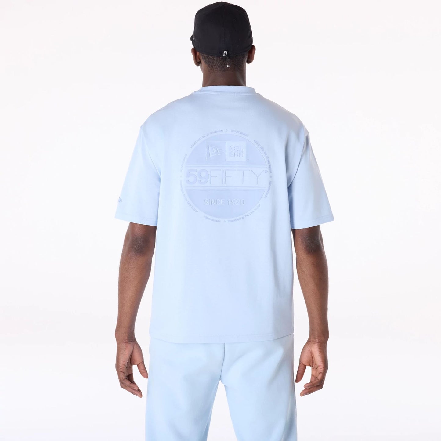 The Male model is wearing New Era Sticker Pastel Blue Oversized T-Shirt 2