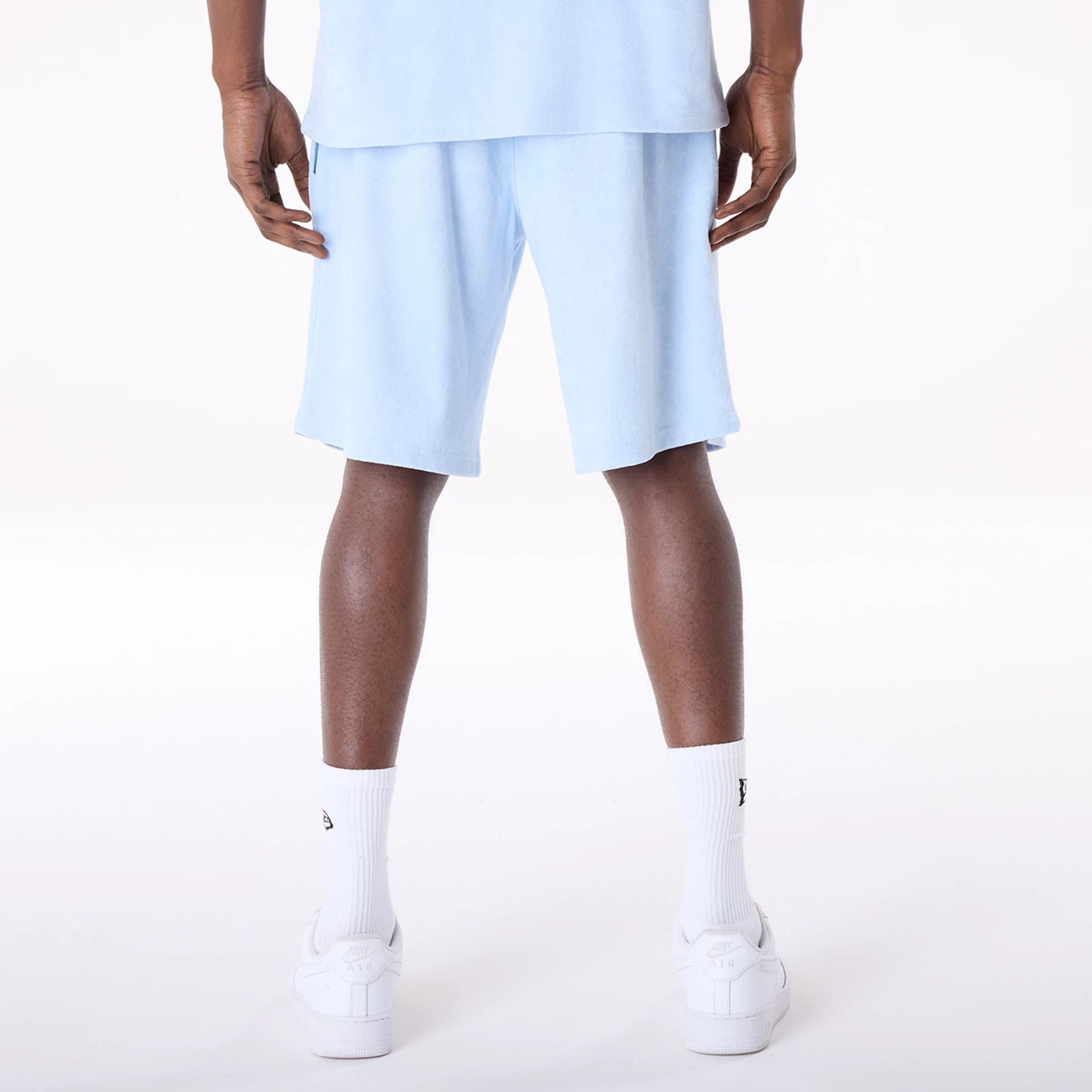 The Male model is wearing New Era Towelling Pastel Blue Shorts 6