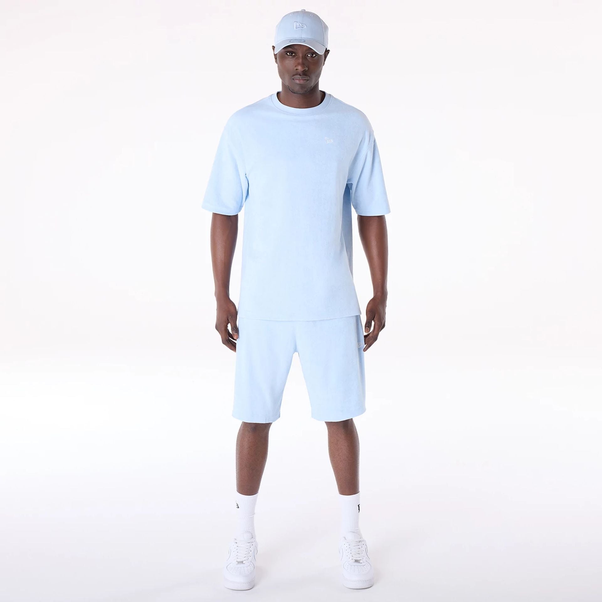 The Male model is wearing New Era Towelling Pastel Blue Shorts 7