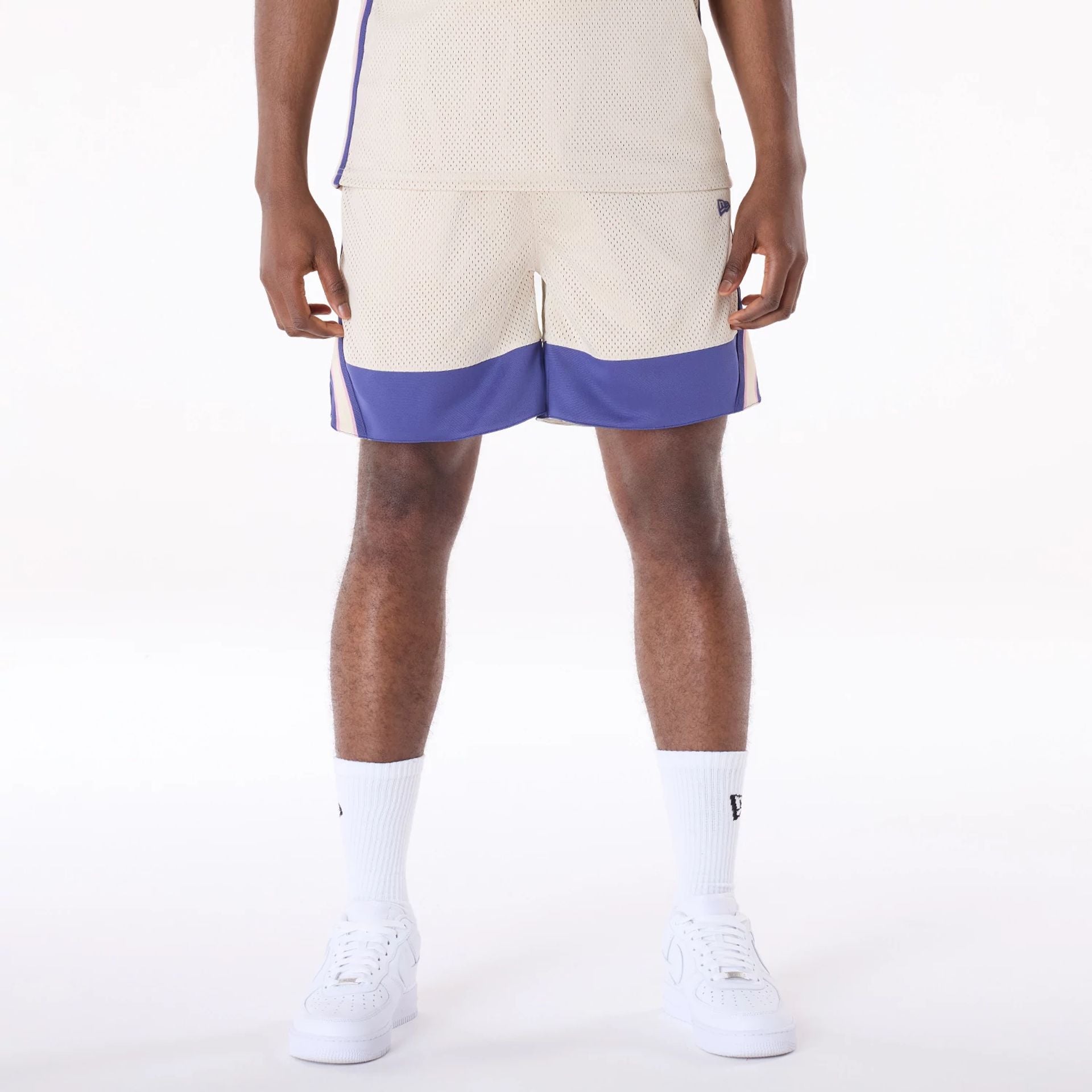 The Male model is wearing New Era Mesh Light Beige Oversized Shorts 1