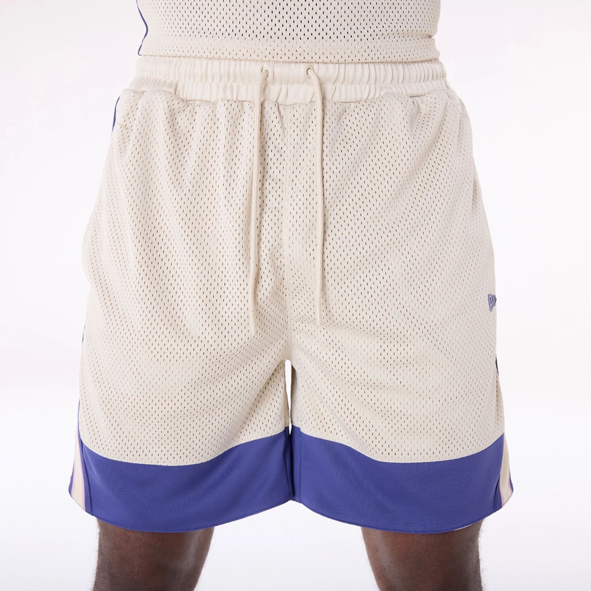 The Male model is wearing New Era Mesh Light Beige Oversized Shorts 3