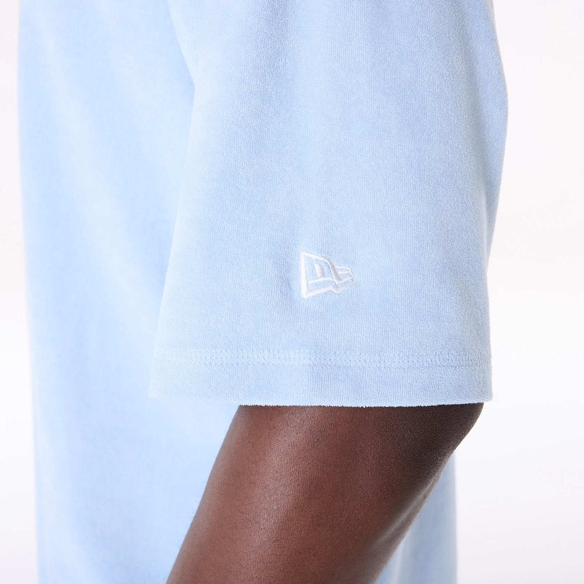 The Male model is wearing New Era Towelling Pastel Blue Oversized T-Shirt 7