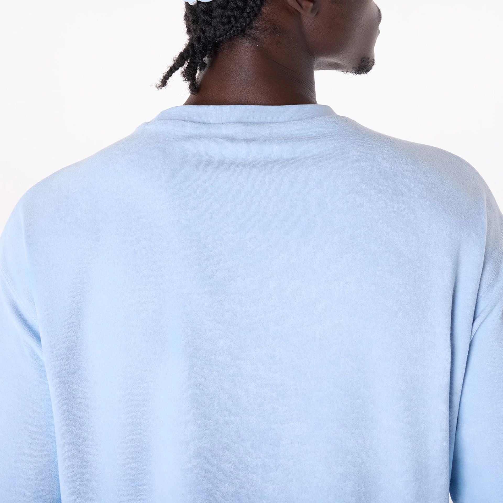 The Male model is wearing New Era Towelling Pastel Blue Oversized T-Shirt 4