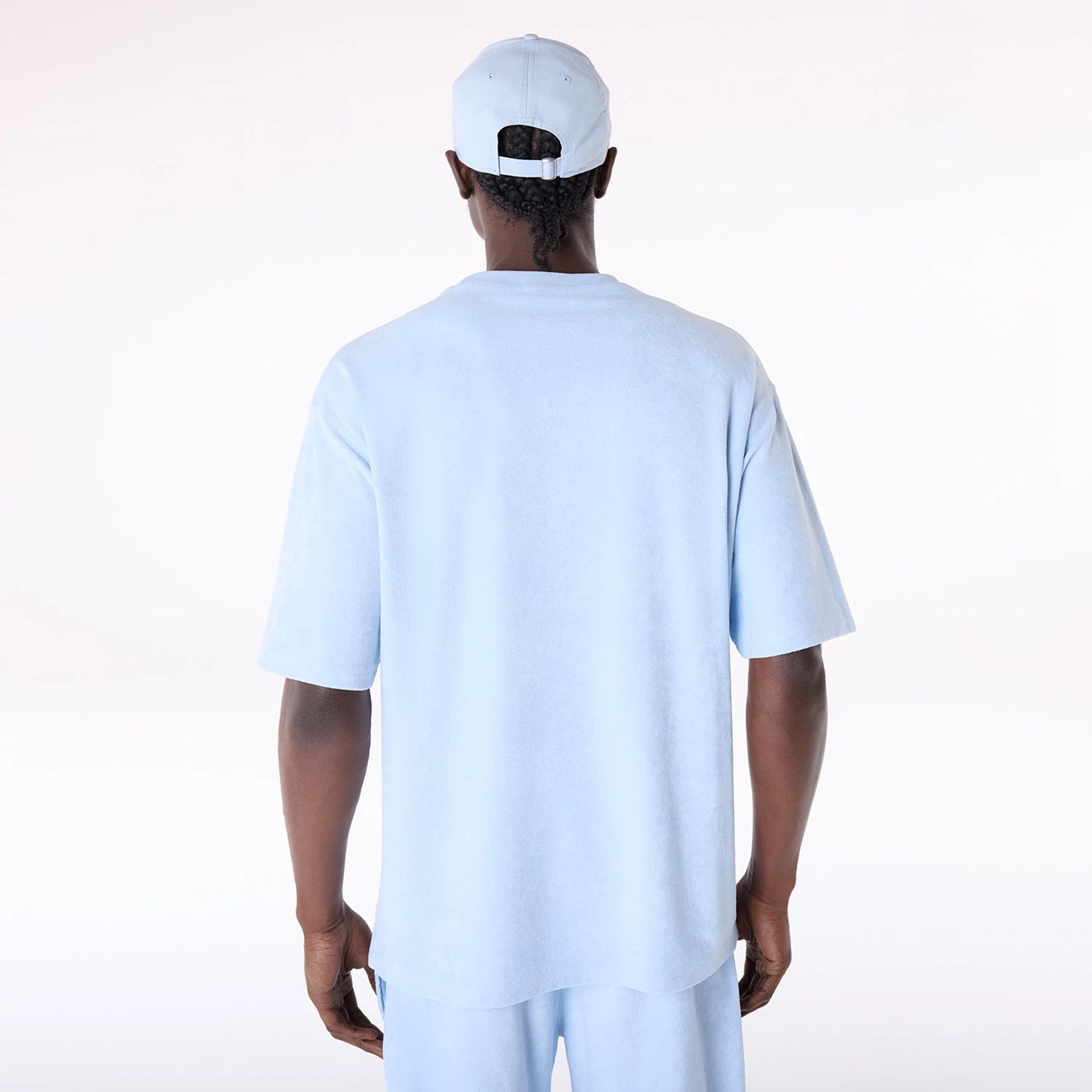 The Male model is wearing New Era Towelling Pastel Blue Oversized T-Shirt 2