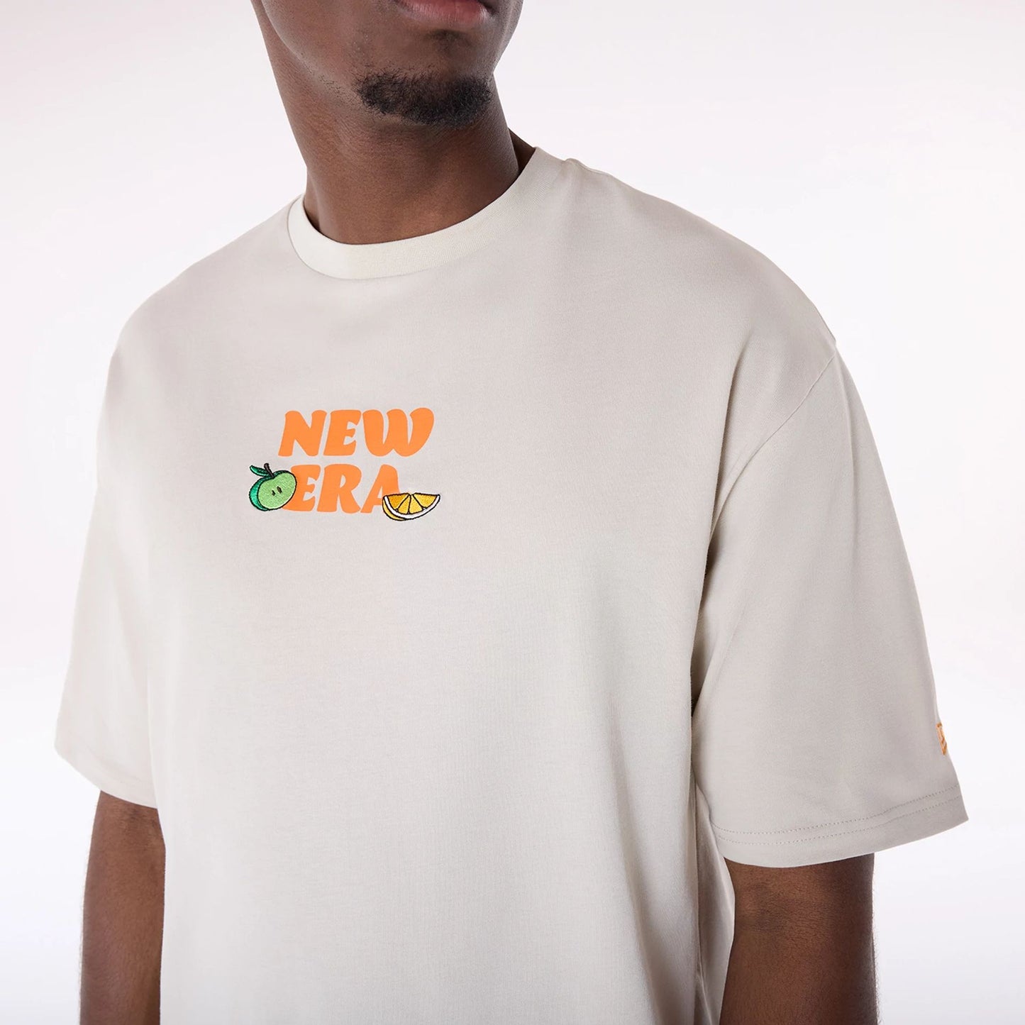 The Male model is wearing New Era Drink Graphic Cream Oversized T-Shirt 5