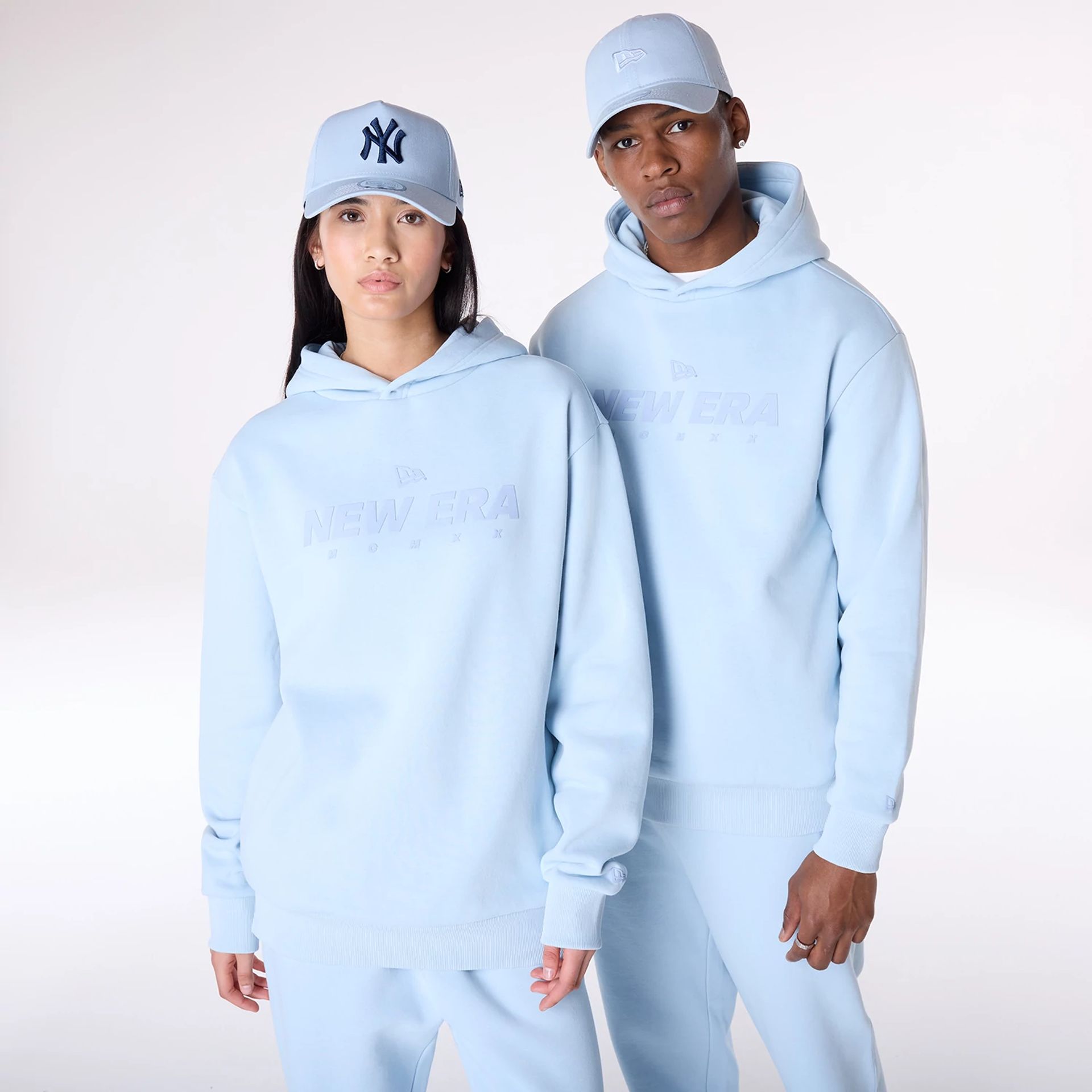 The Male model is wearing New Era Flag Pastel Blue Oversized Pullover Hoodie 1