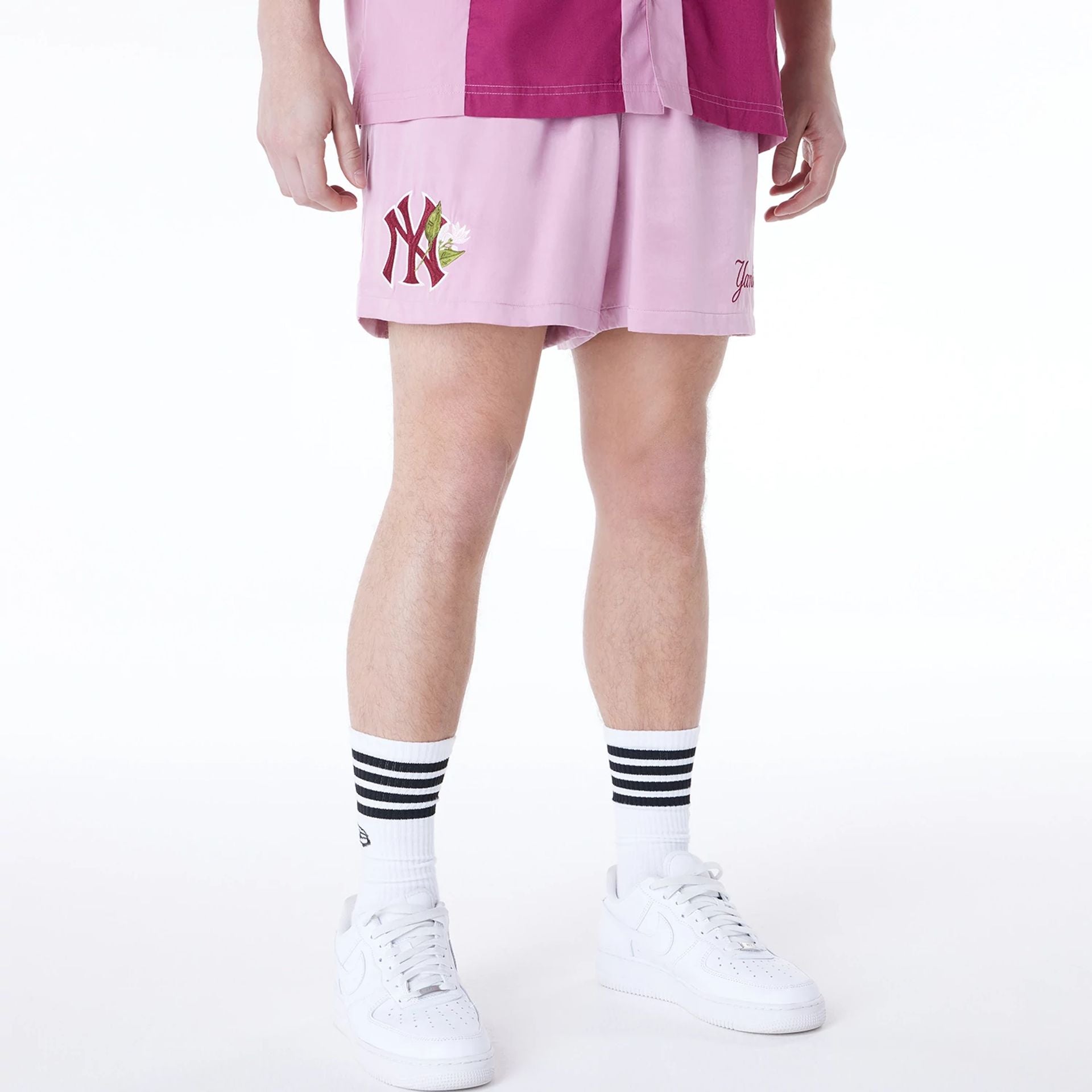 The Male model is wearing New York Yankees MLB Woven Dark Pink Shorts 1