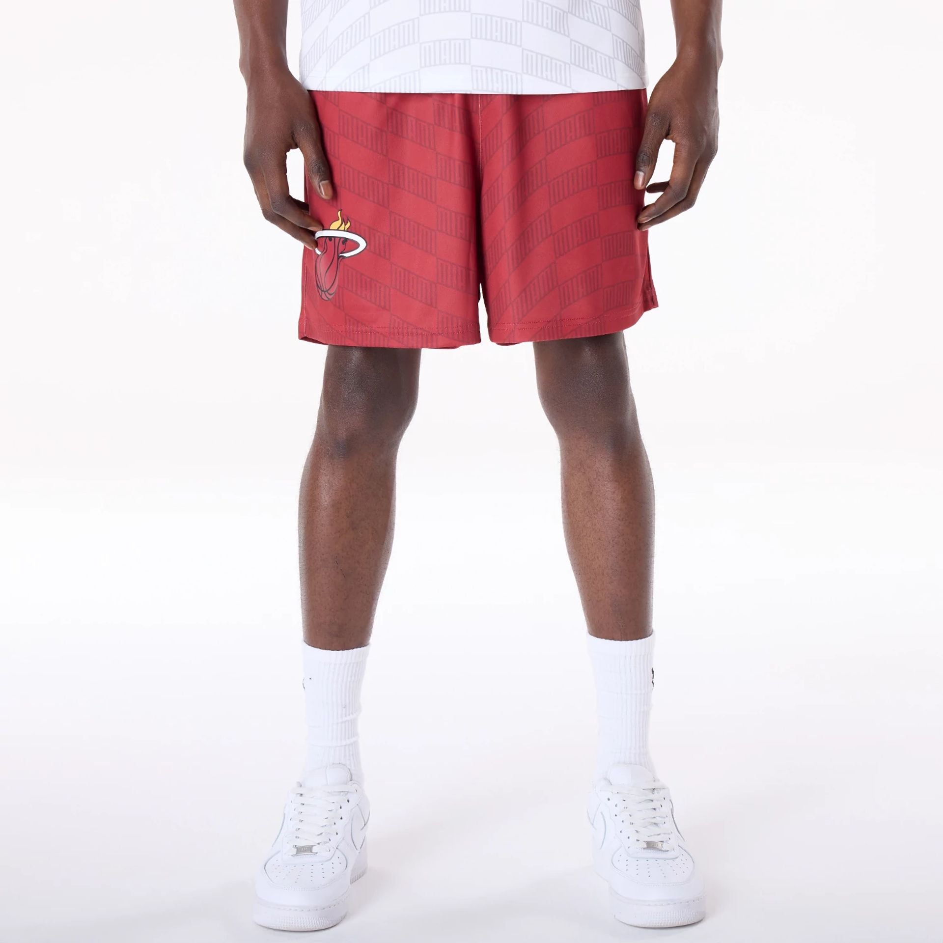 The Male model is wearing Miami Heat NBA All Over Print Graphic Dark Red Shorts 1