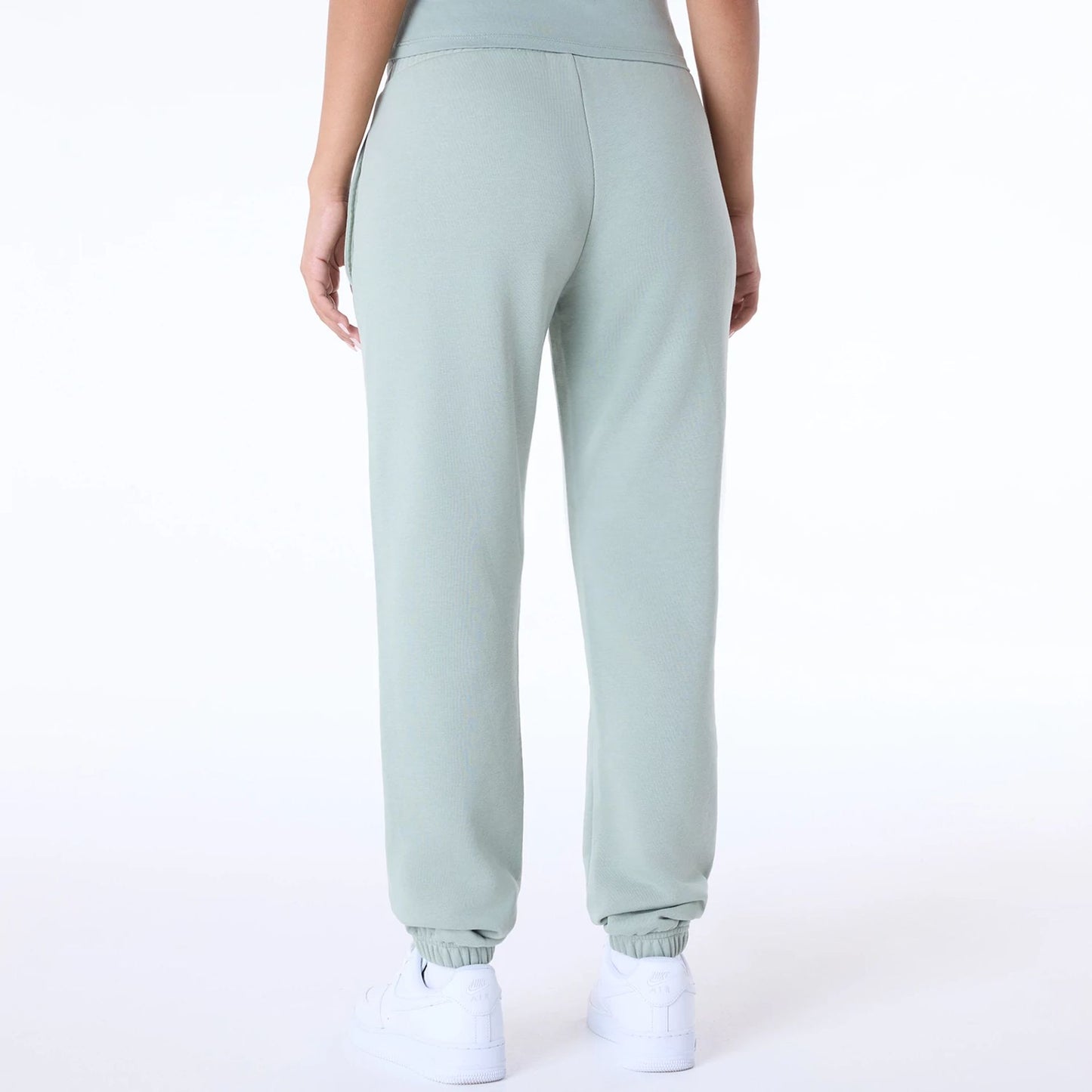 The Female model is wearing Womens New Era Script Pastel Green Joggers 7