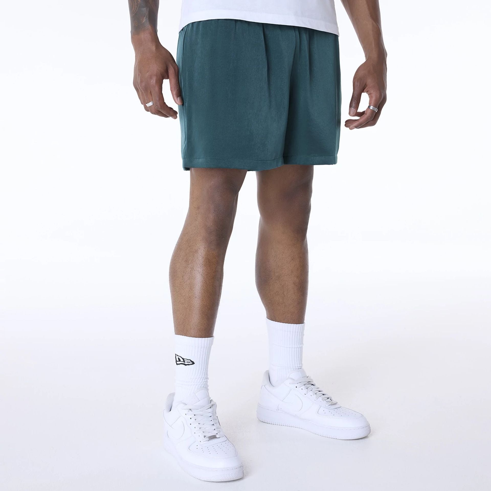 The Male model is wearing New Era Woven Dark Green Shorts 2