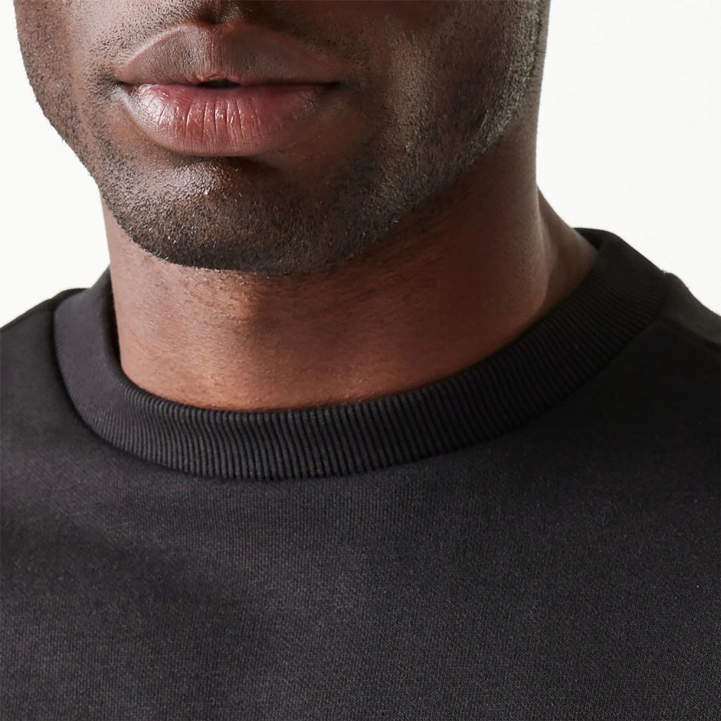 The Male model is wearing New Era Essential Brushed Fleece Black Crewneck Sweater 6