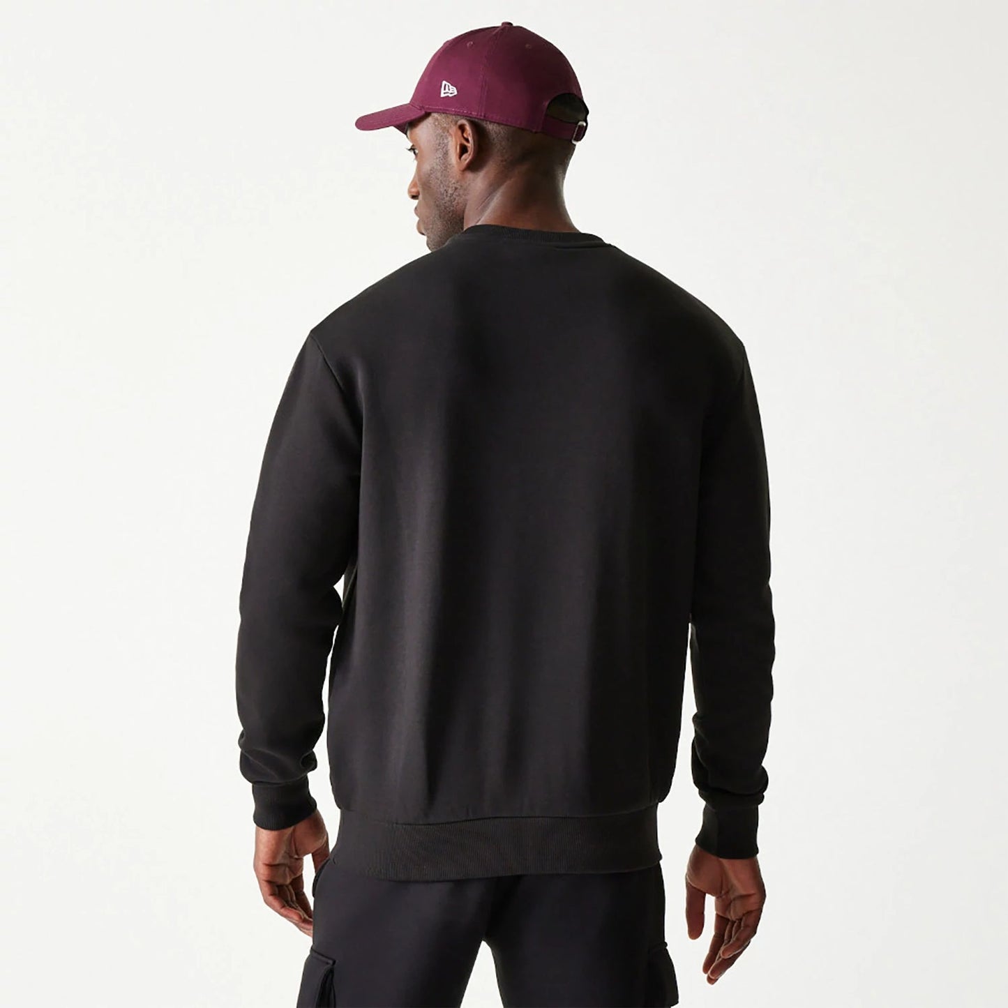 The Male model is wearing New Era Essential Brushed Fleece Black Crewneck Sweater 2