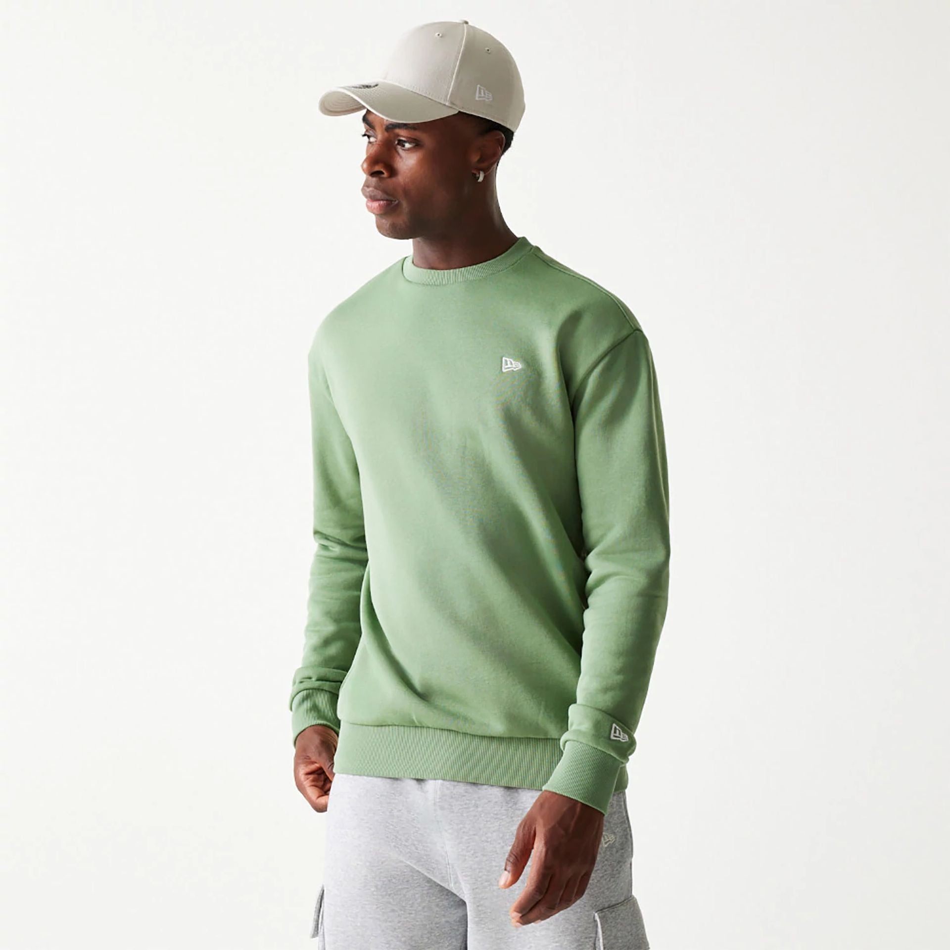 The Male model is wearing New Era Essential Brushed Fleece Green Crewneck Sweater 1