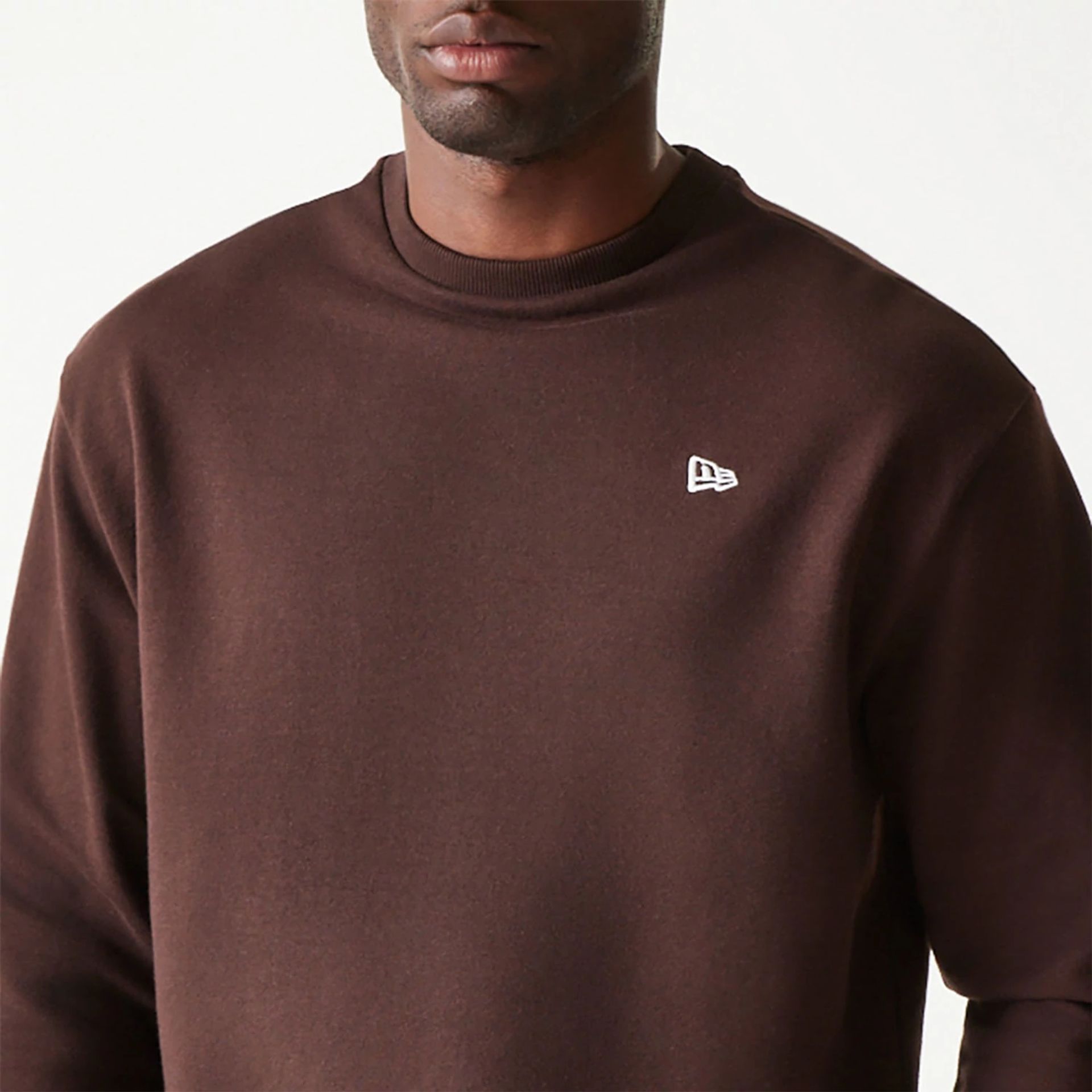 The Male model is wearing New Era Essential Dark Brown Crewneck Sweater 3