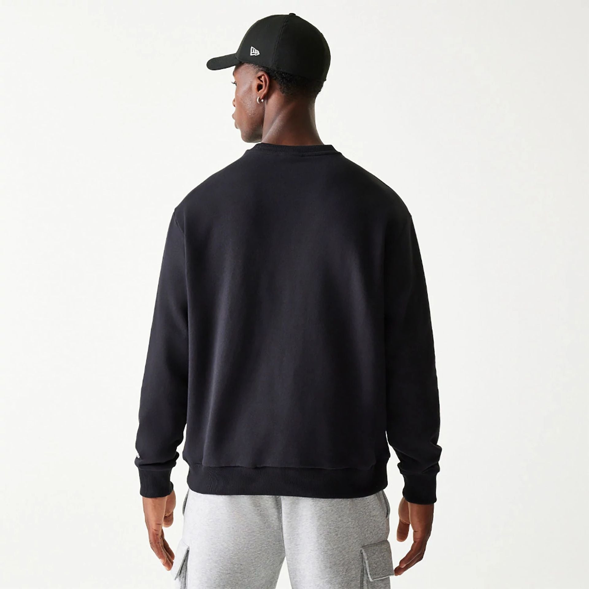 The Male model is wearing New Era Essential Black Crewneck Sweater 2