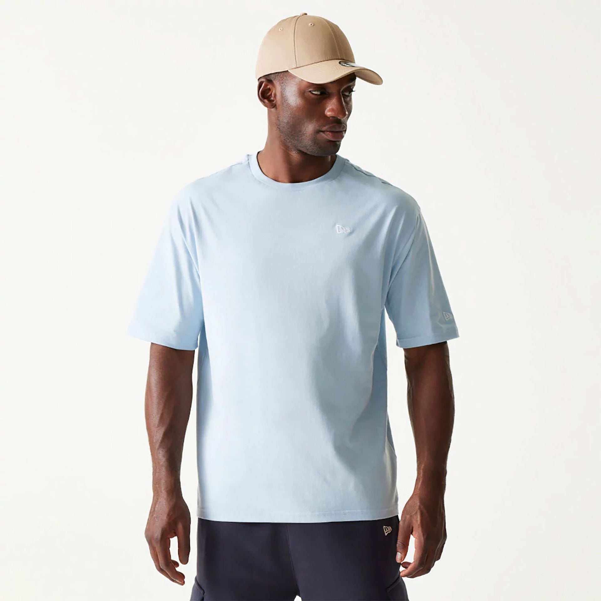 The Male model is wearing New Era Essential Pastel Blue Oversized T-Shirt 1