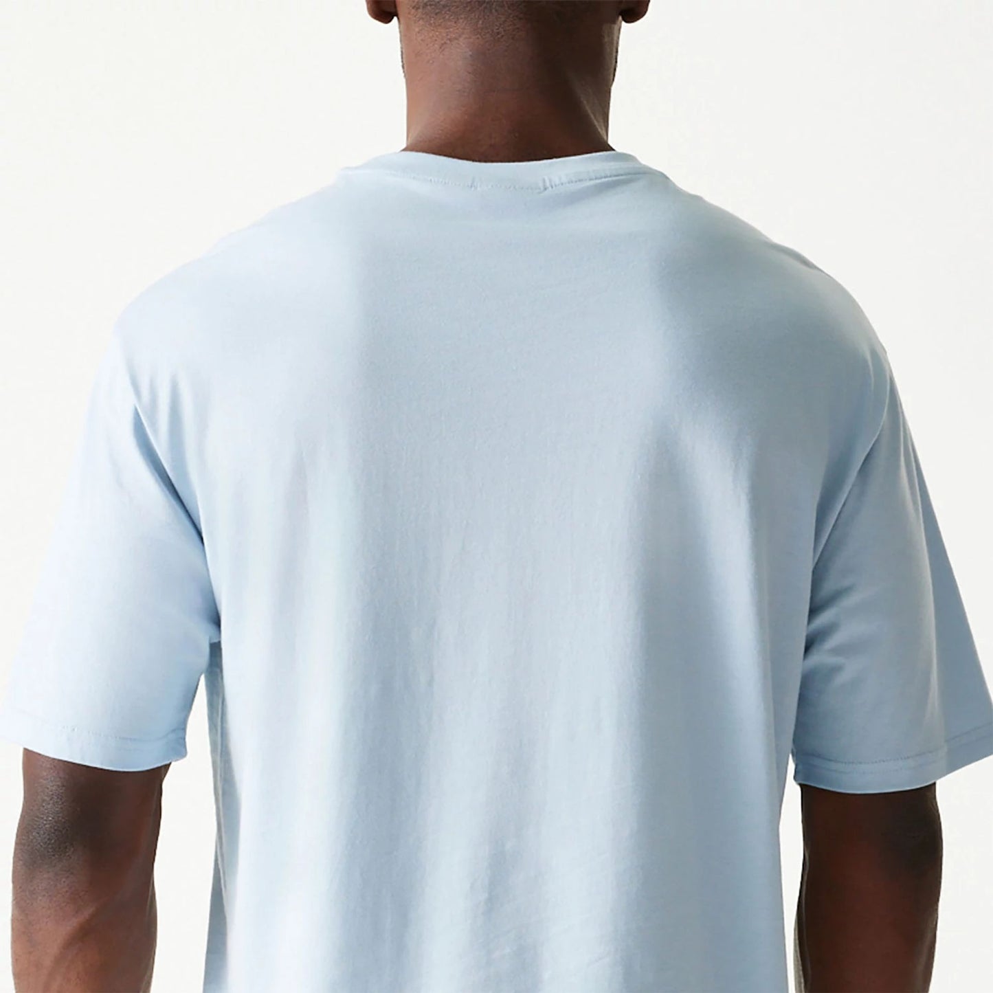 The Male model is wearing New Era Essential Pastel Blue Oversized T-Shirt 7