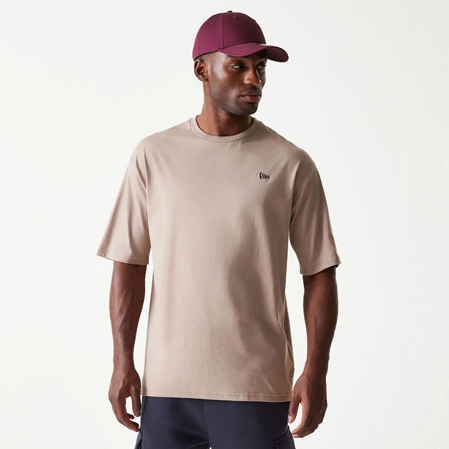 The Male model is wearing New Era Essential Pastel Brown Oversized T-Shirt 1