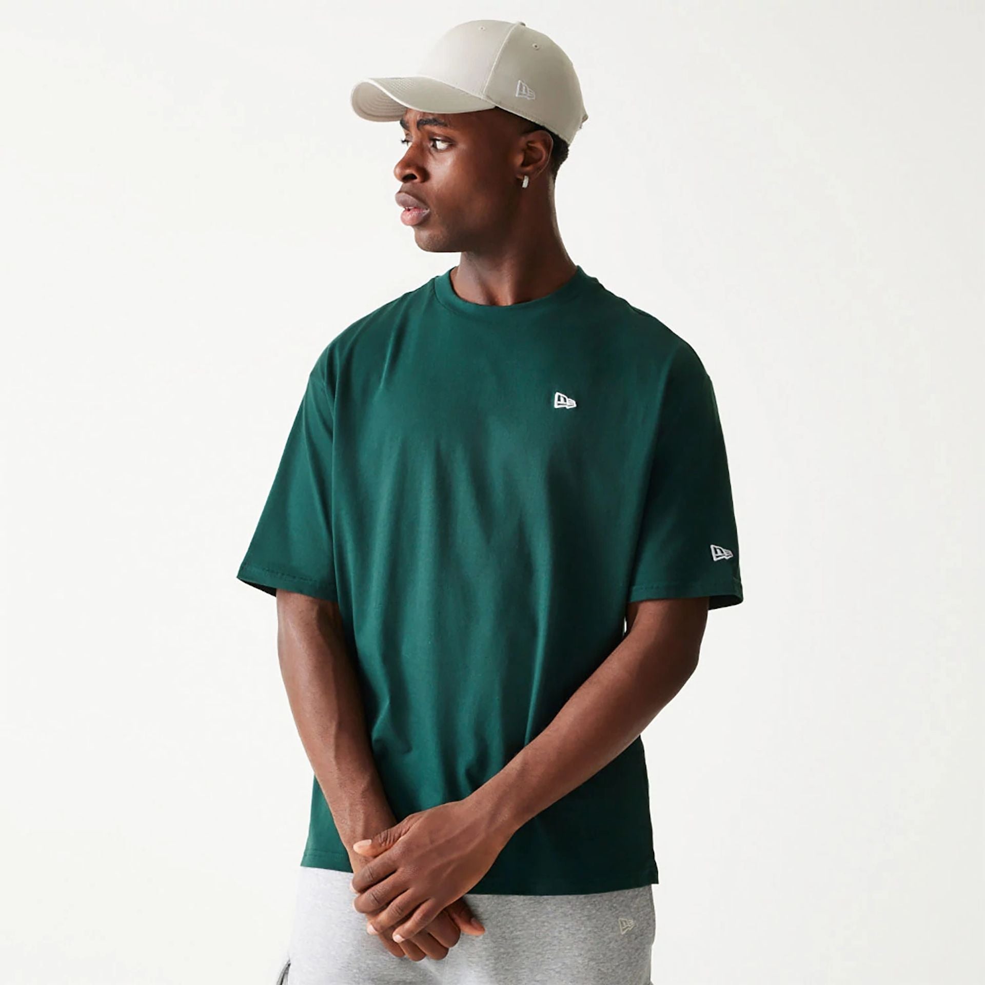 The Male model is wearing New Era Essential Dark Green Oversized T-Shirt 1