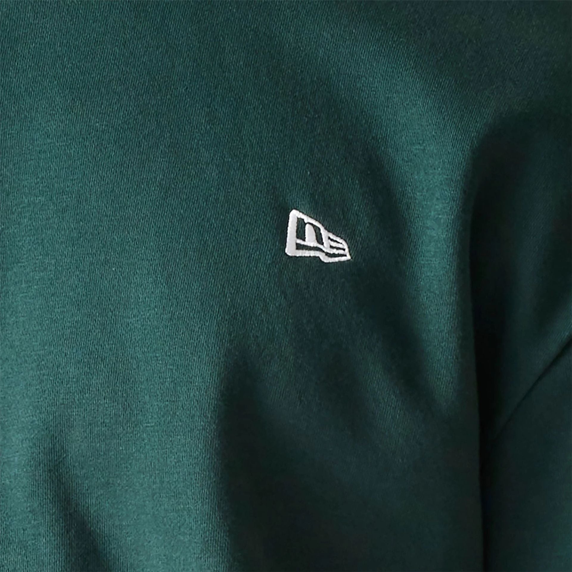 The Male model is wearing New Era Essential Brushed Fleece Dark Green Crewneck Sweater 4