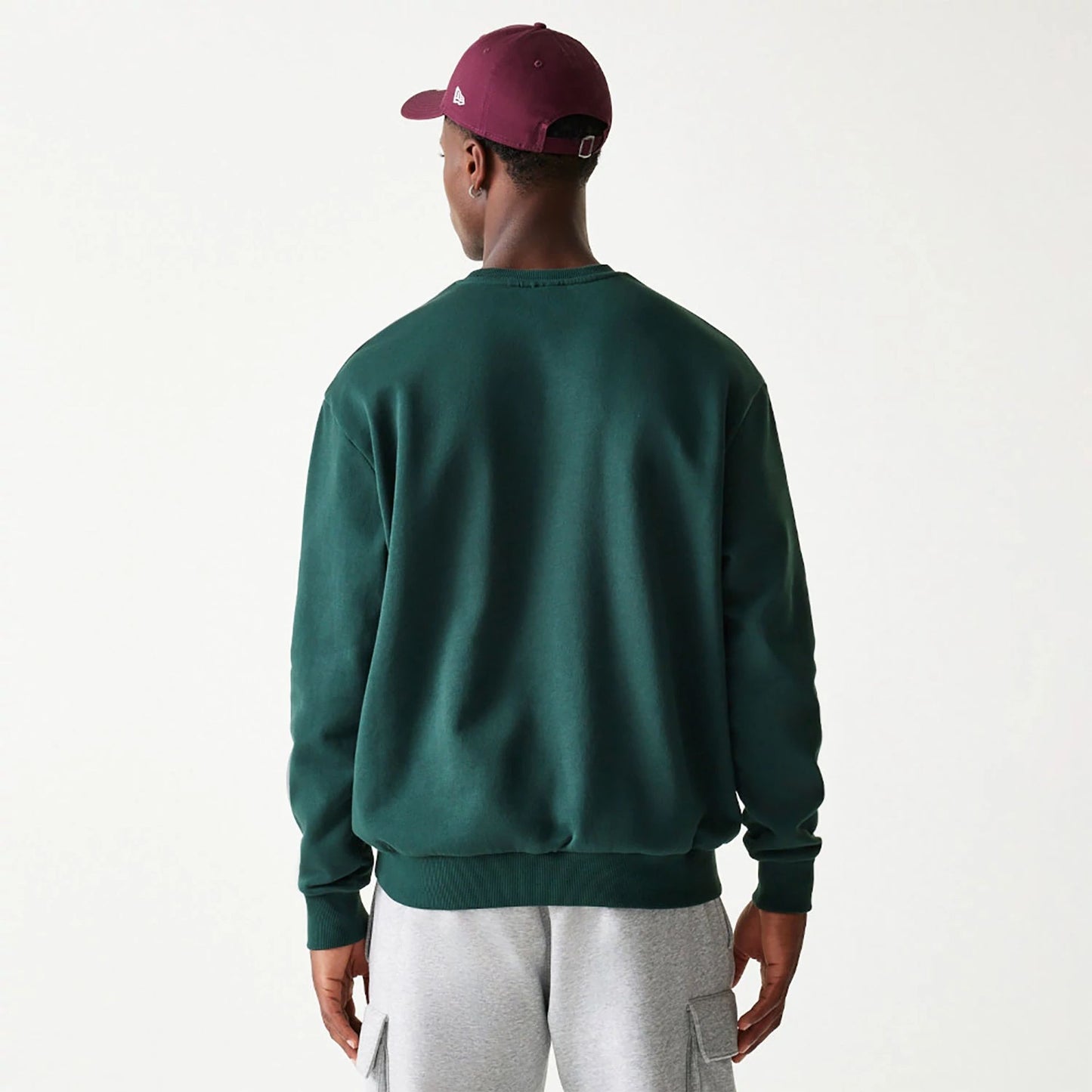 The Male model is wearing New Era Essential Brushed Fleece Dark Green Crewneck Sweater 2