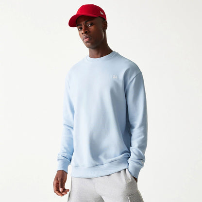 The Male model is wearing New Era Essential Pastel Blue Crewneck Sweater 1