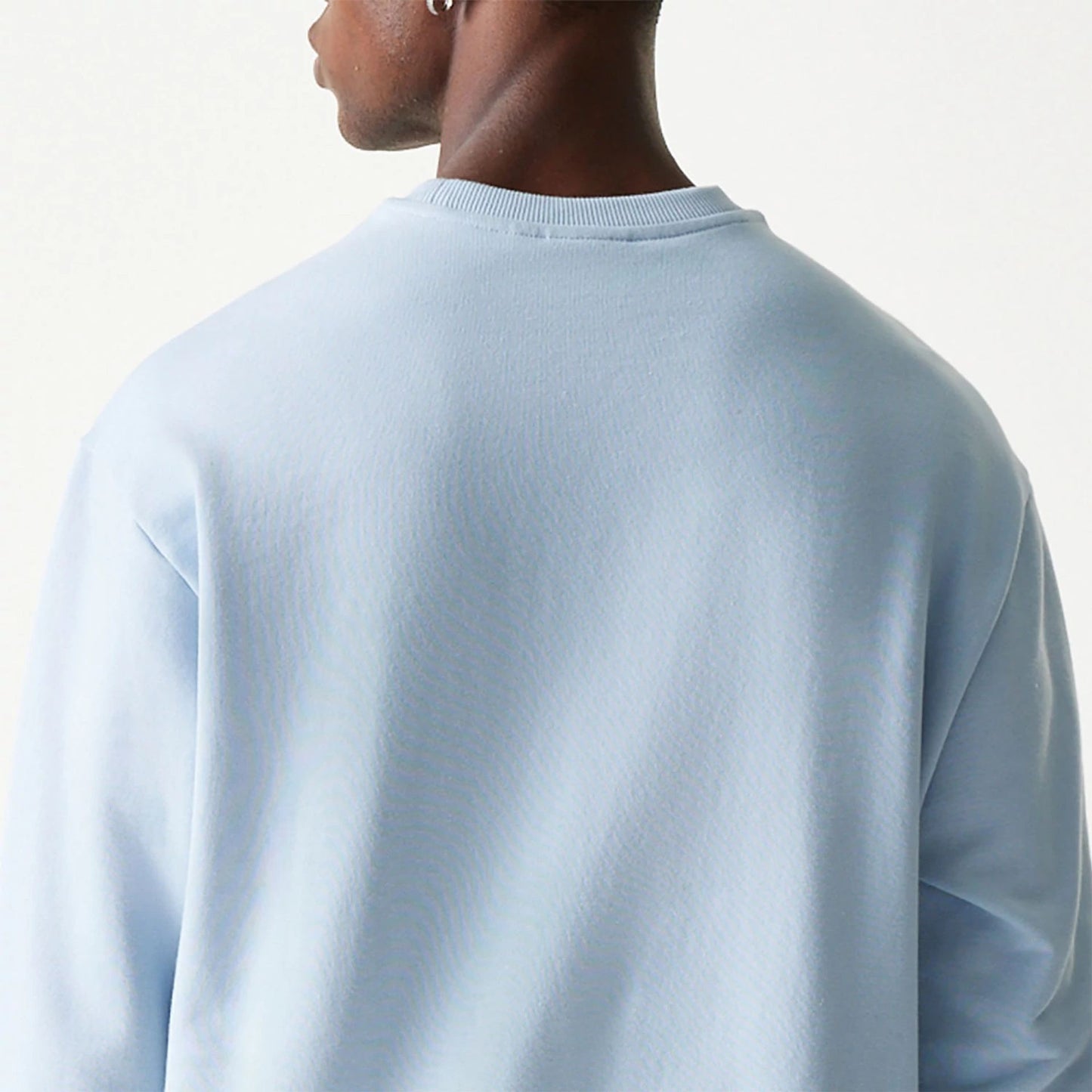 The Male model is wearing New Era Essential Pastel Blue Crewneck Sweater 7