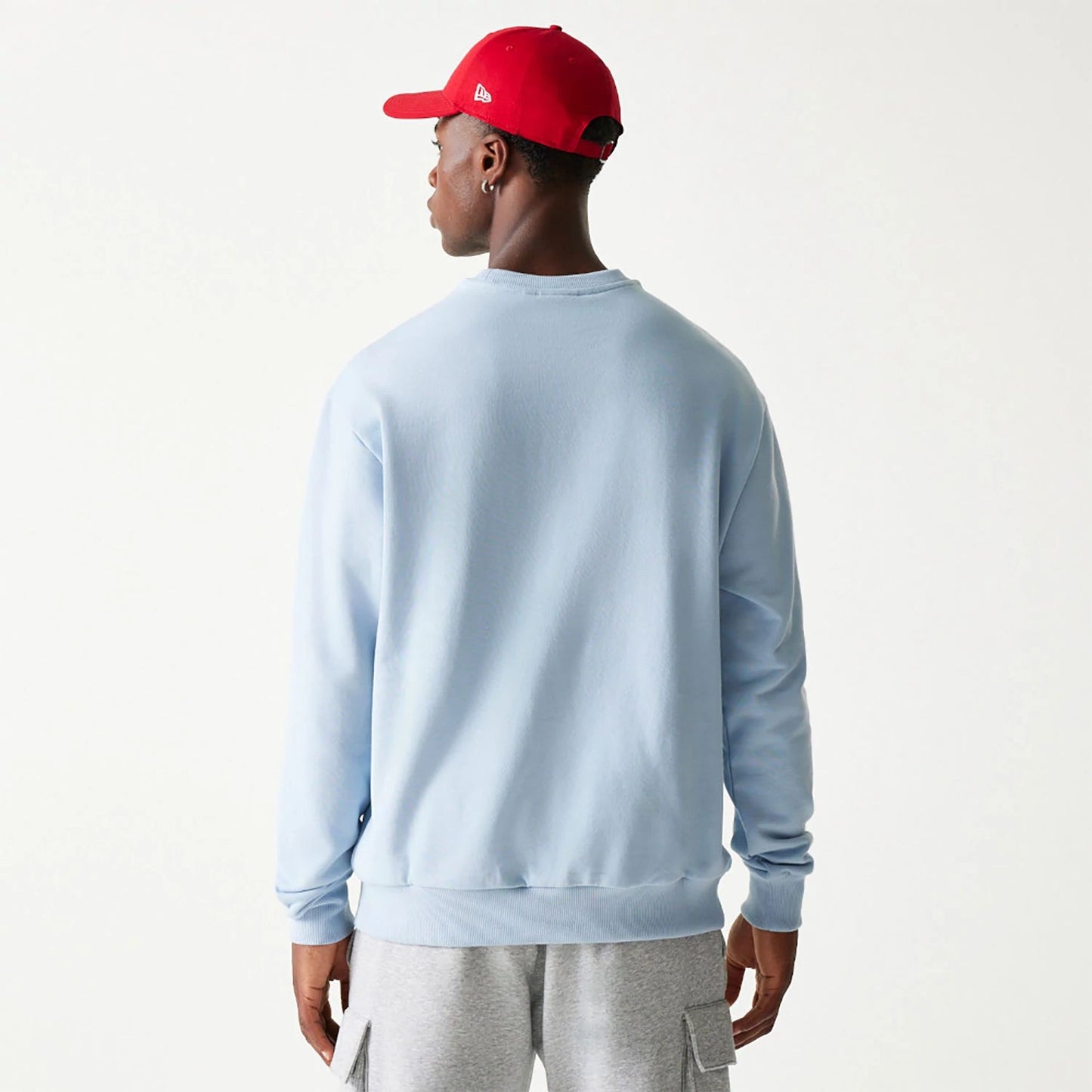 The Male model is wearing New Era Essential Pastel Blue Crewneck Sweater 2