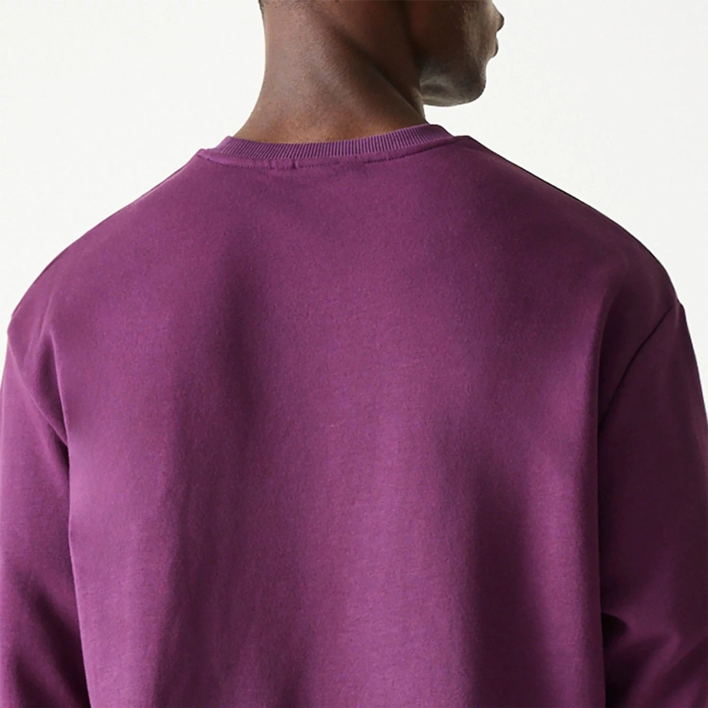 The Male model is wearing New Era Essential Brushed Fleece Dark Purple Crewneck Sweater 7